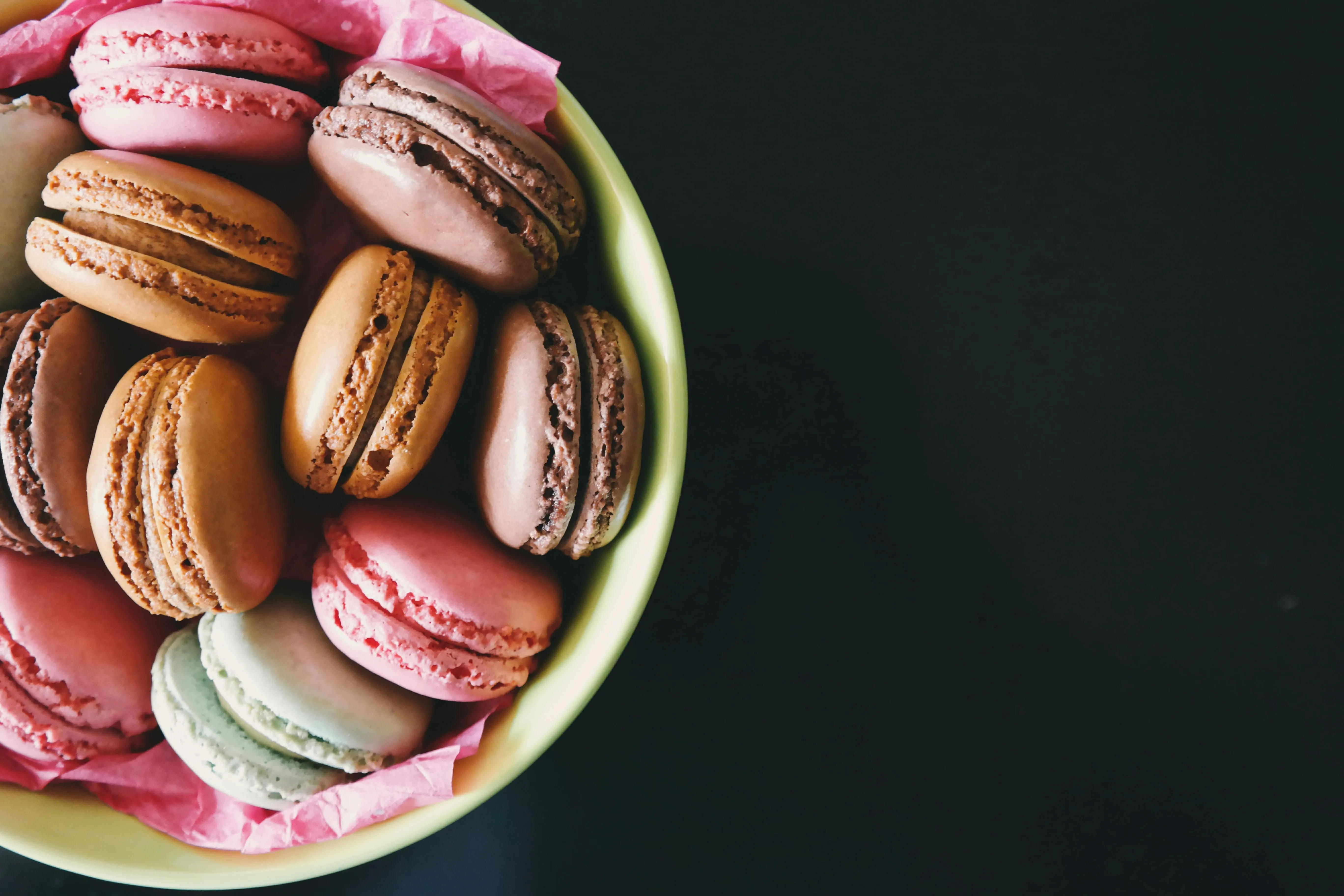 Bowl of colourful macarons on a dark background Wallpaper