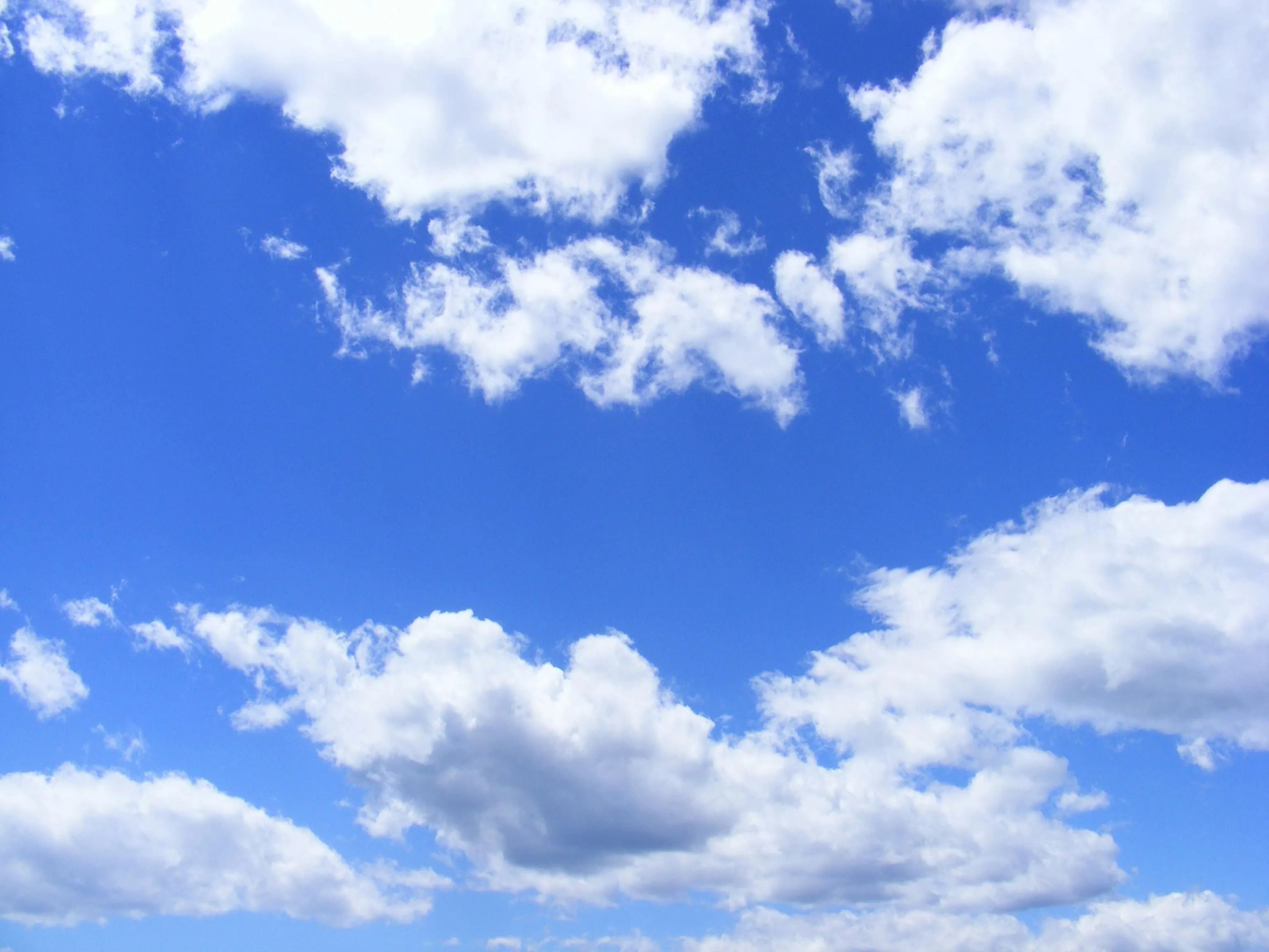 Bright blue sky with fluffy white clouds background image