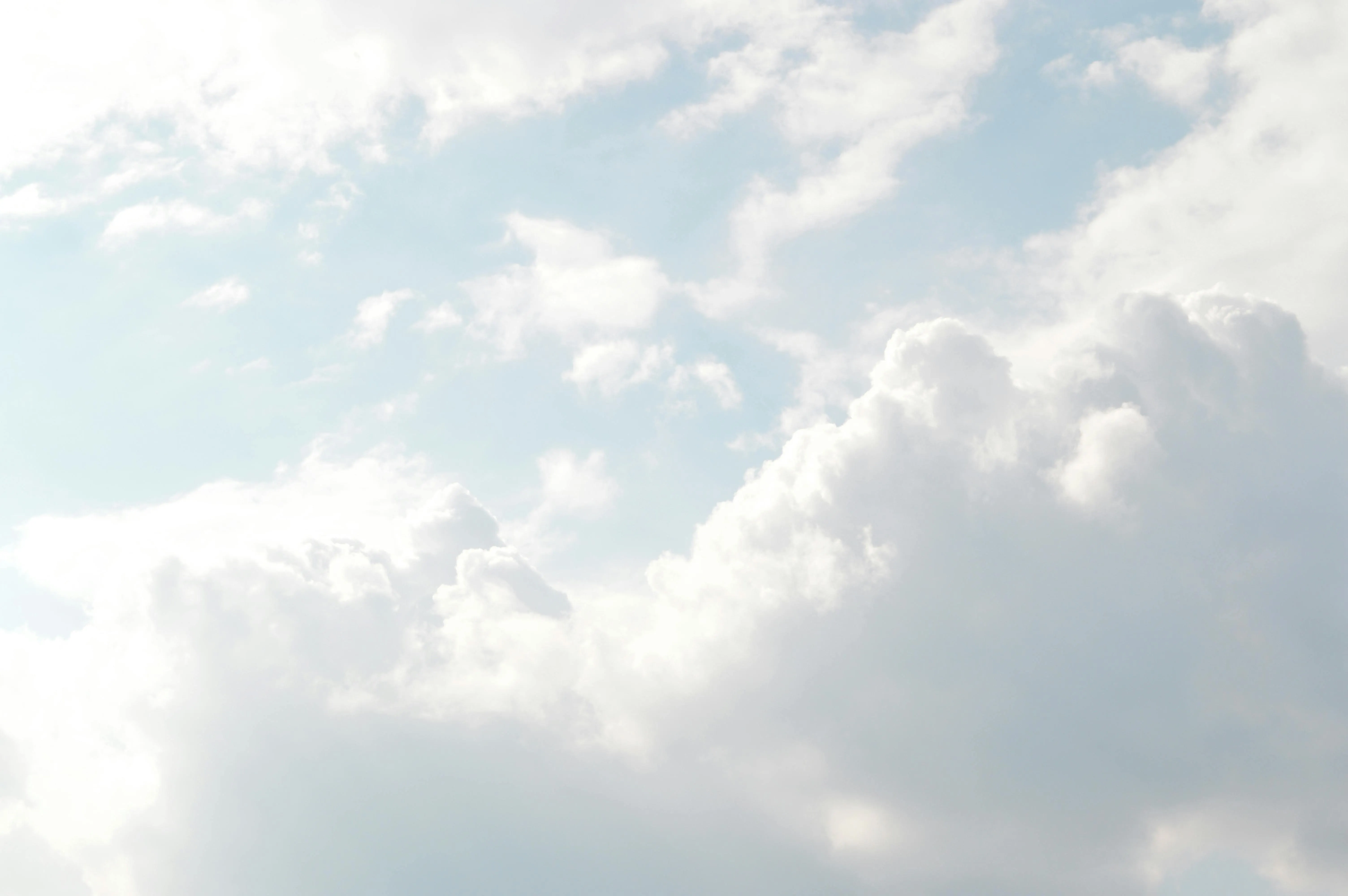Bright cloudy sky with soft white clouds in blue tones image