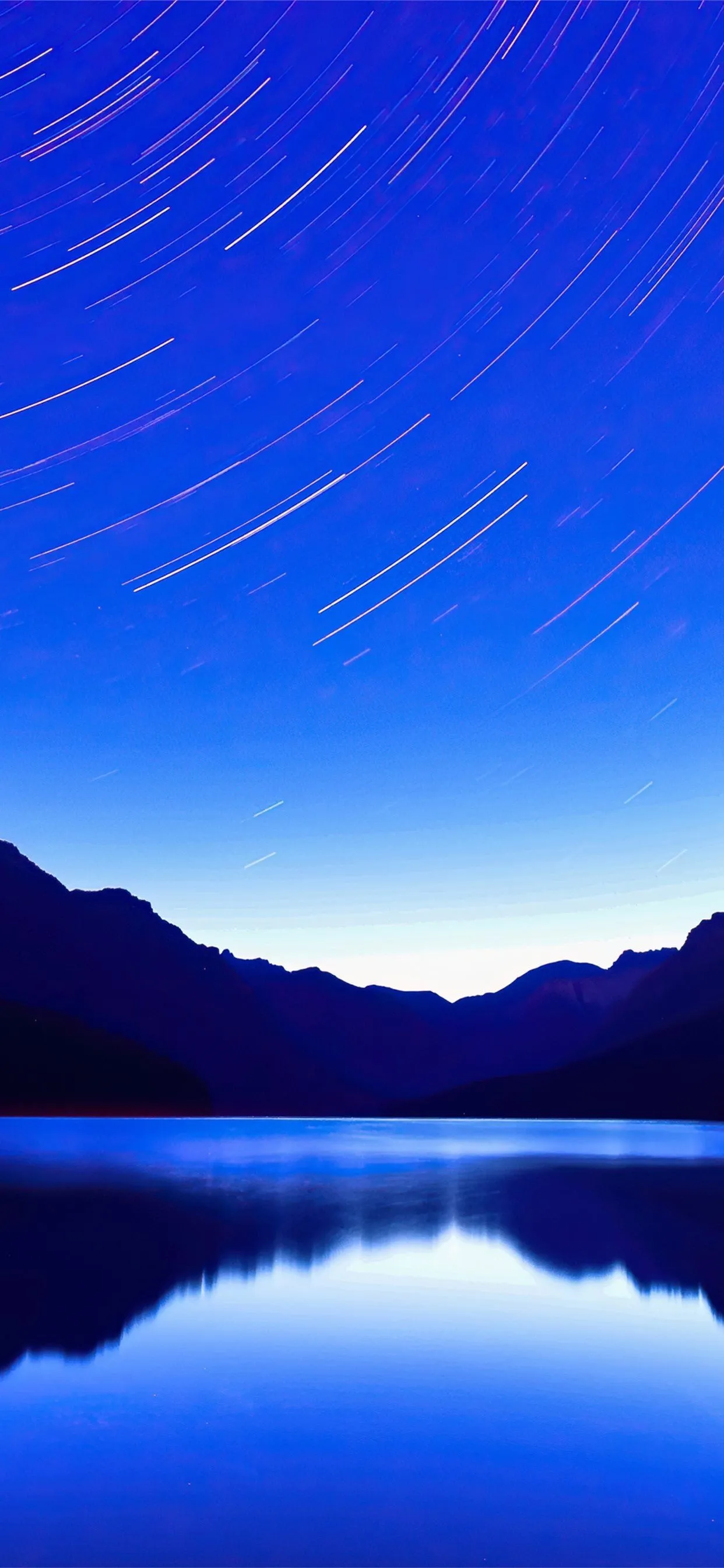 Bright night sky with stars over a calm reflective lake
