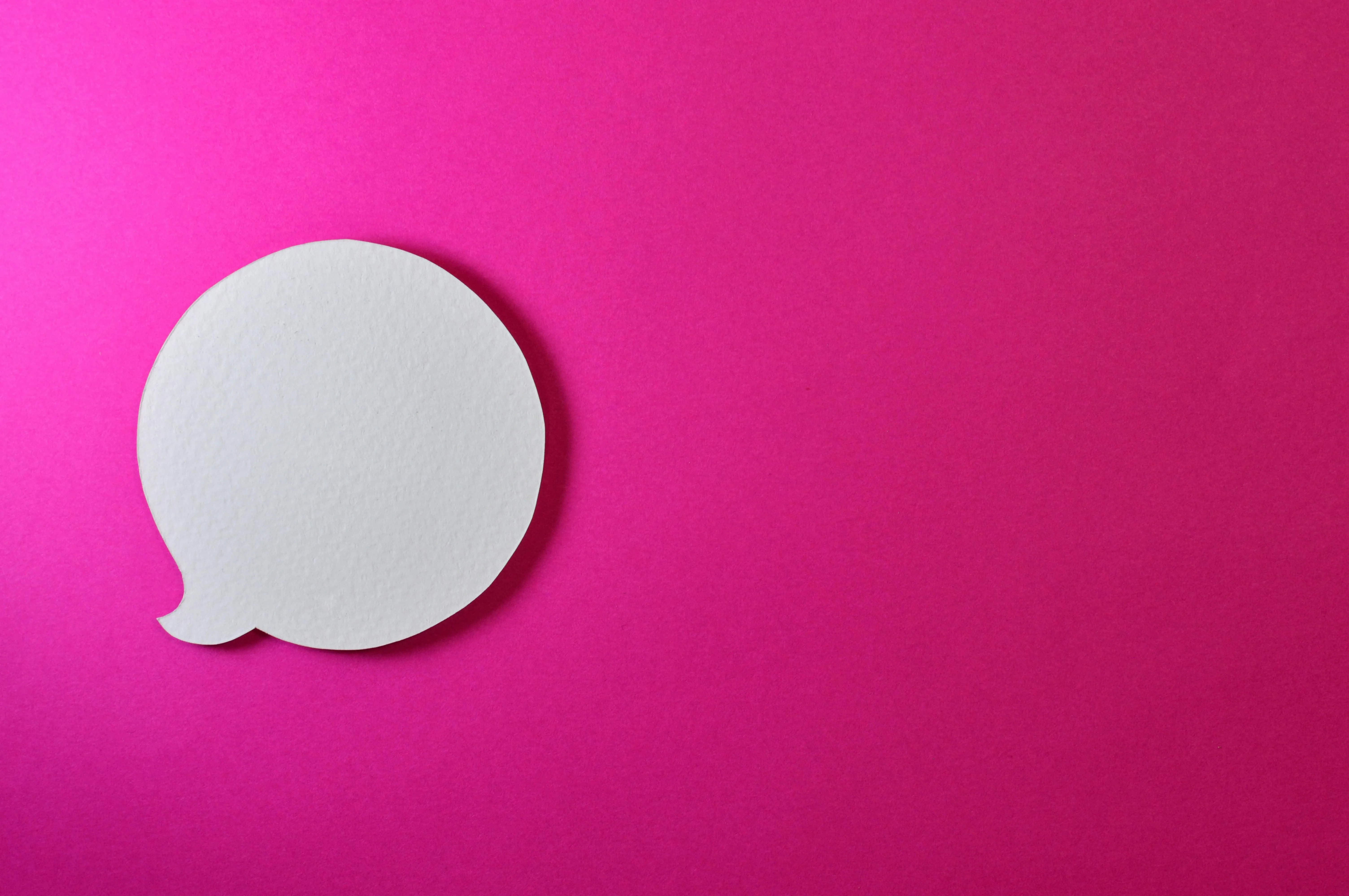 Bright pink background with a white speech bubble shape