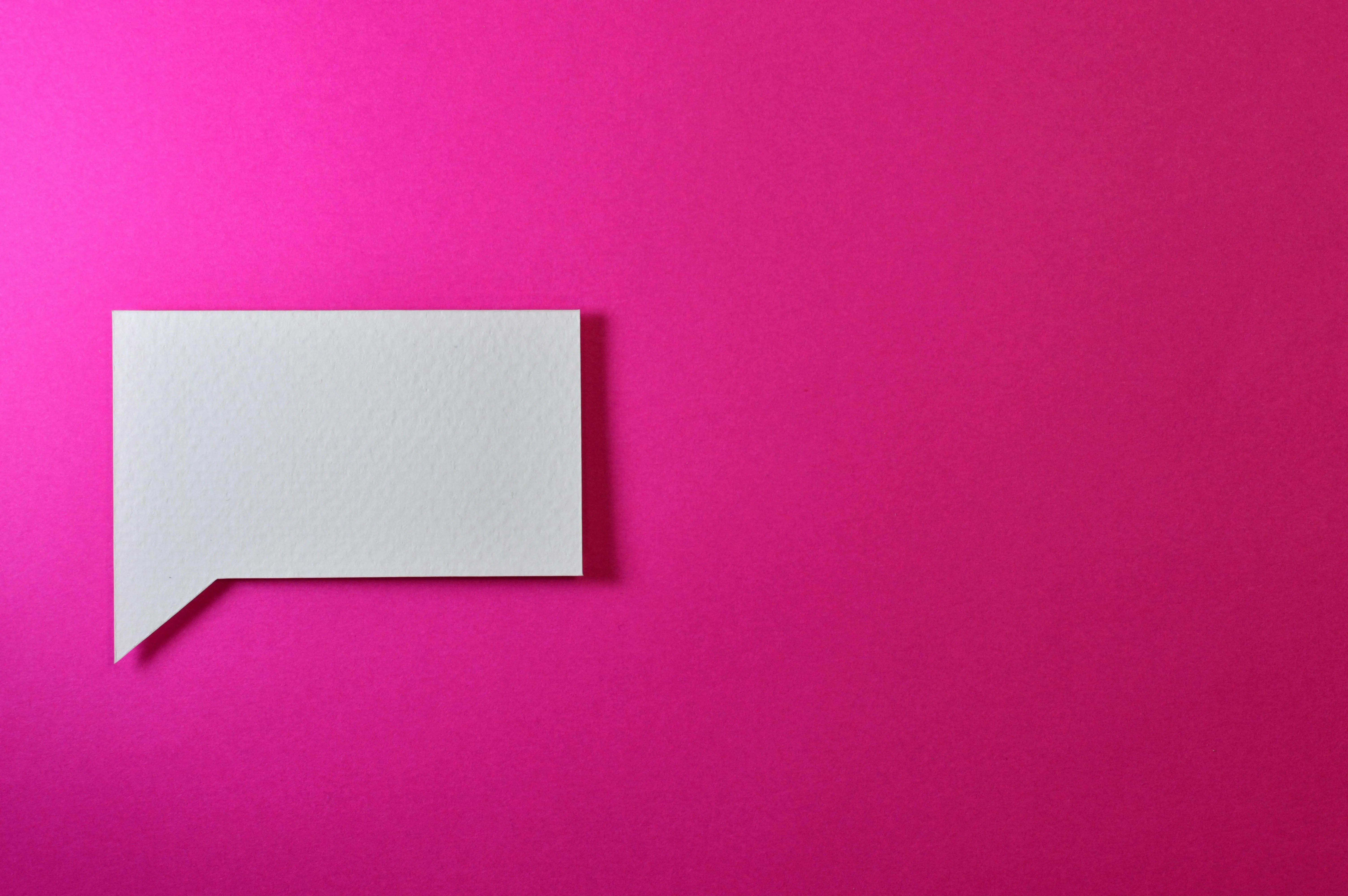 Bright pink background with a white square speech bubble