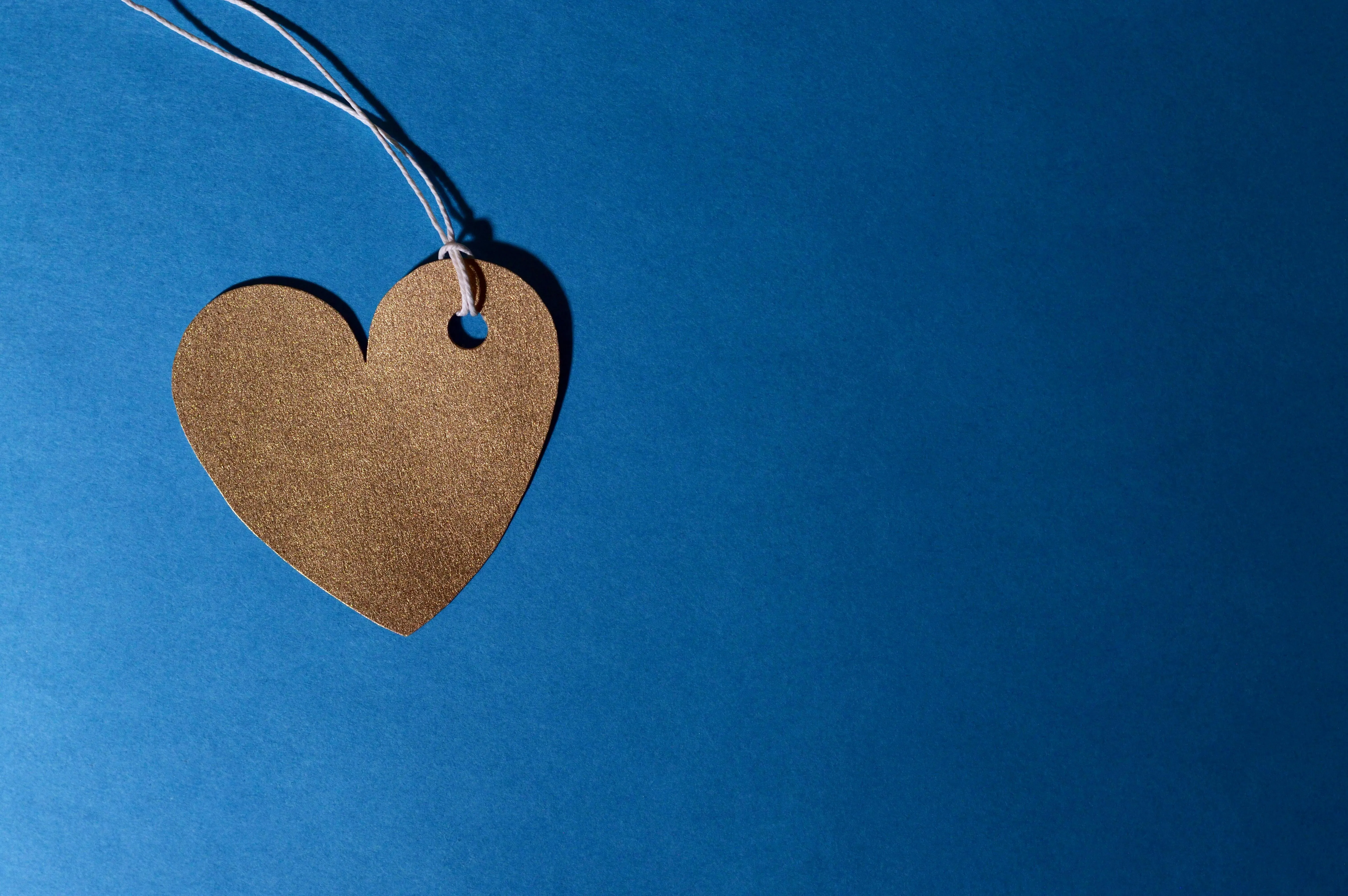 Brown heart shaped tag on a blue background free Wallpaper