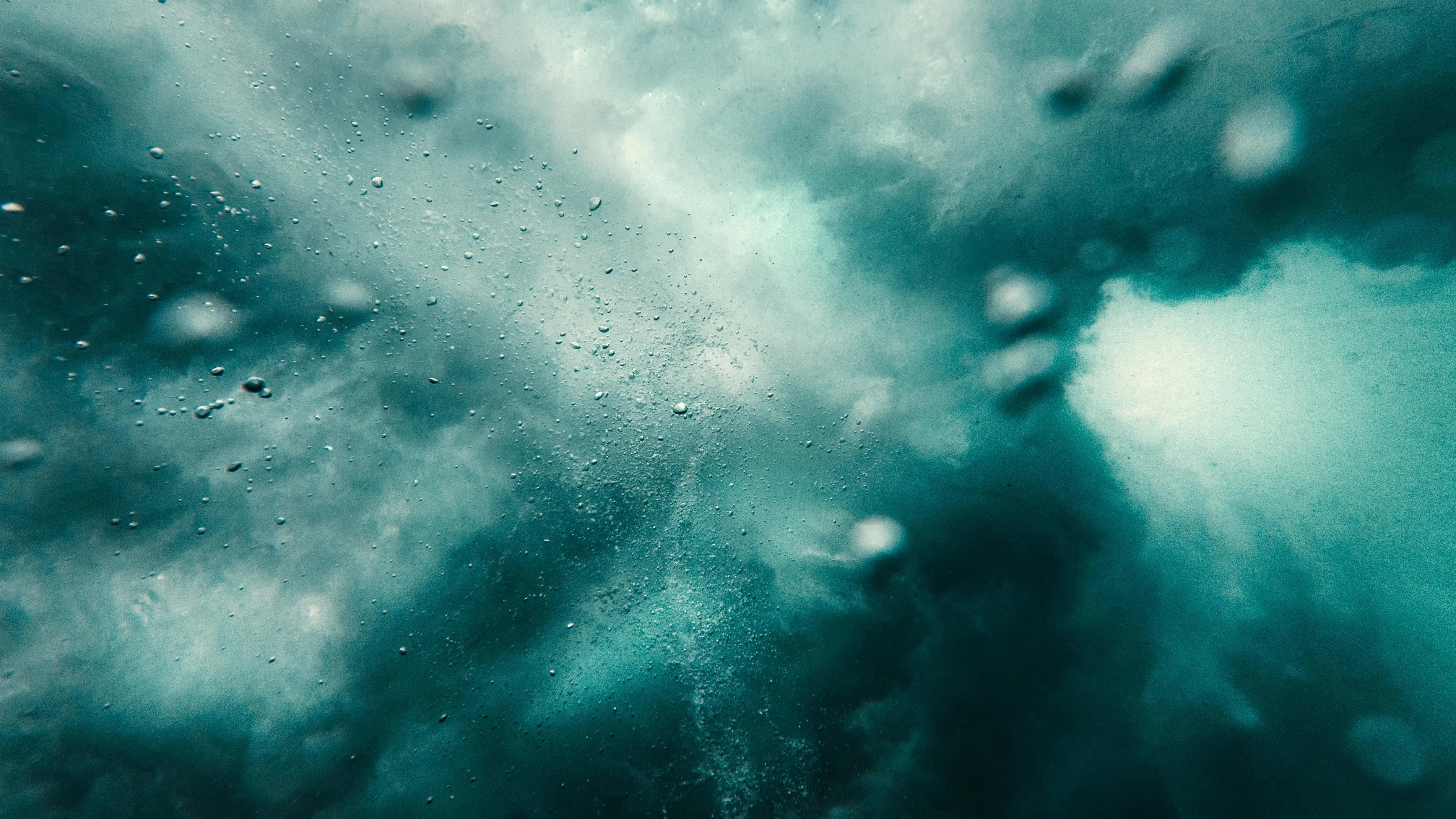 Bubbles rising through the blue water in an underwater image