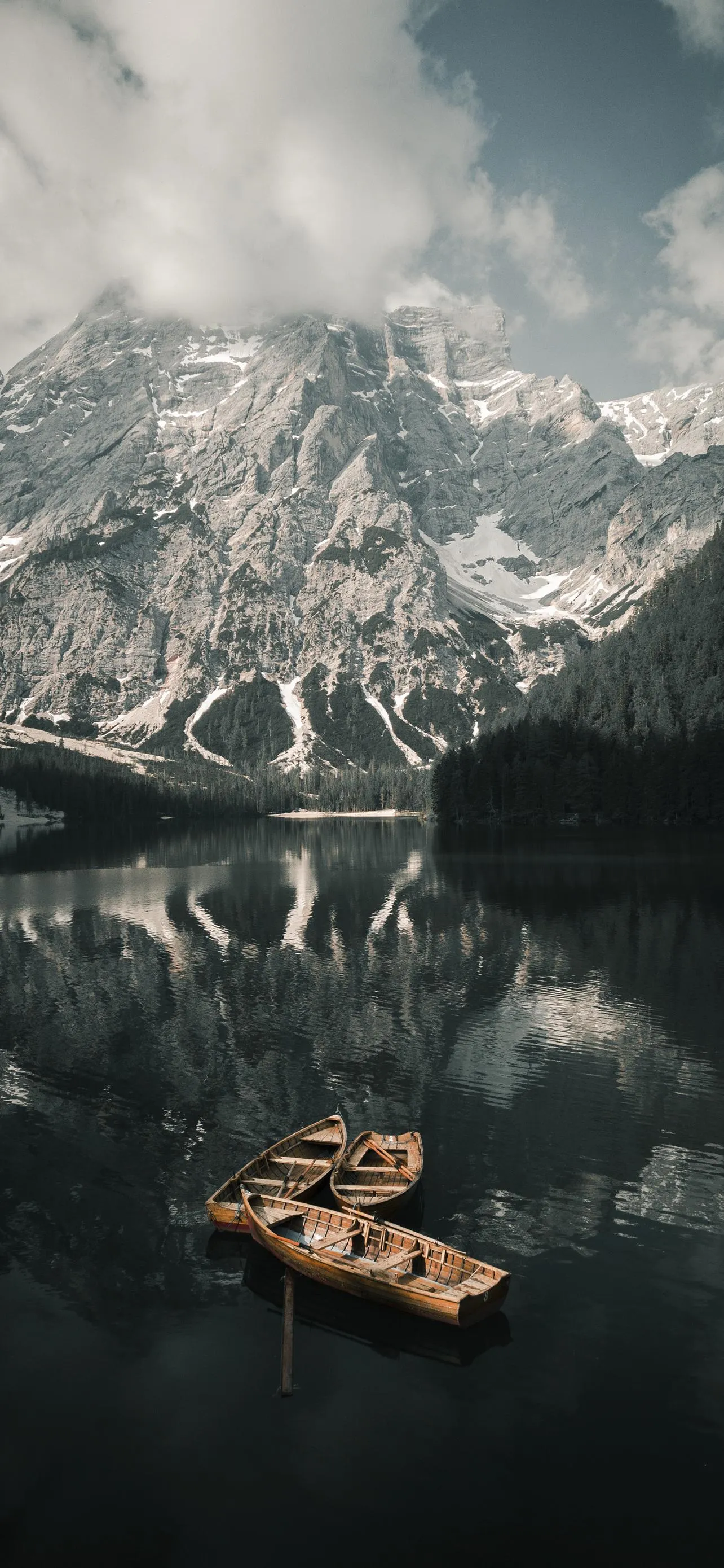 Calm Lake Reflects Majestic Snowy Peaks and Serene Boat