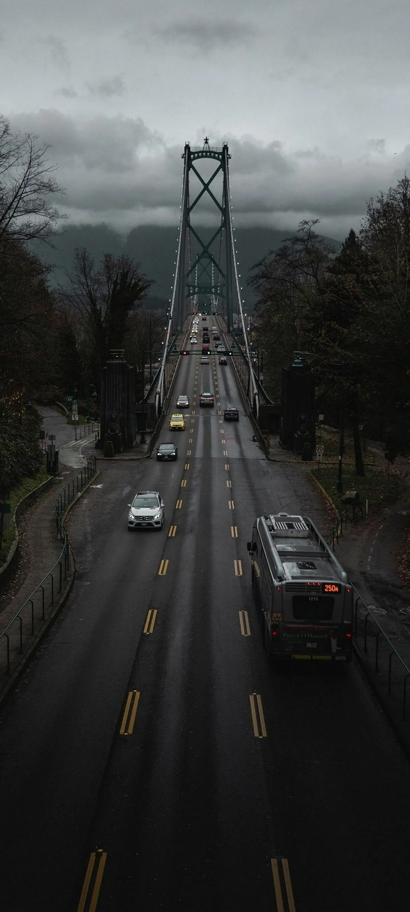 Cars Driving on a Foggy Suspension Bridge in the Morning