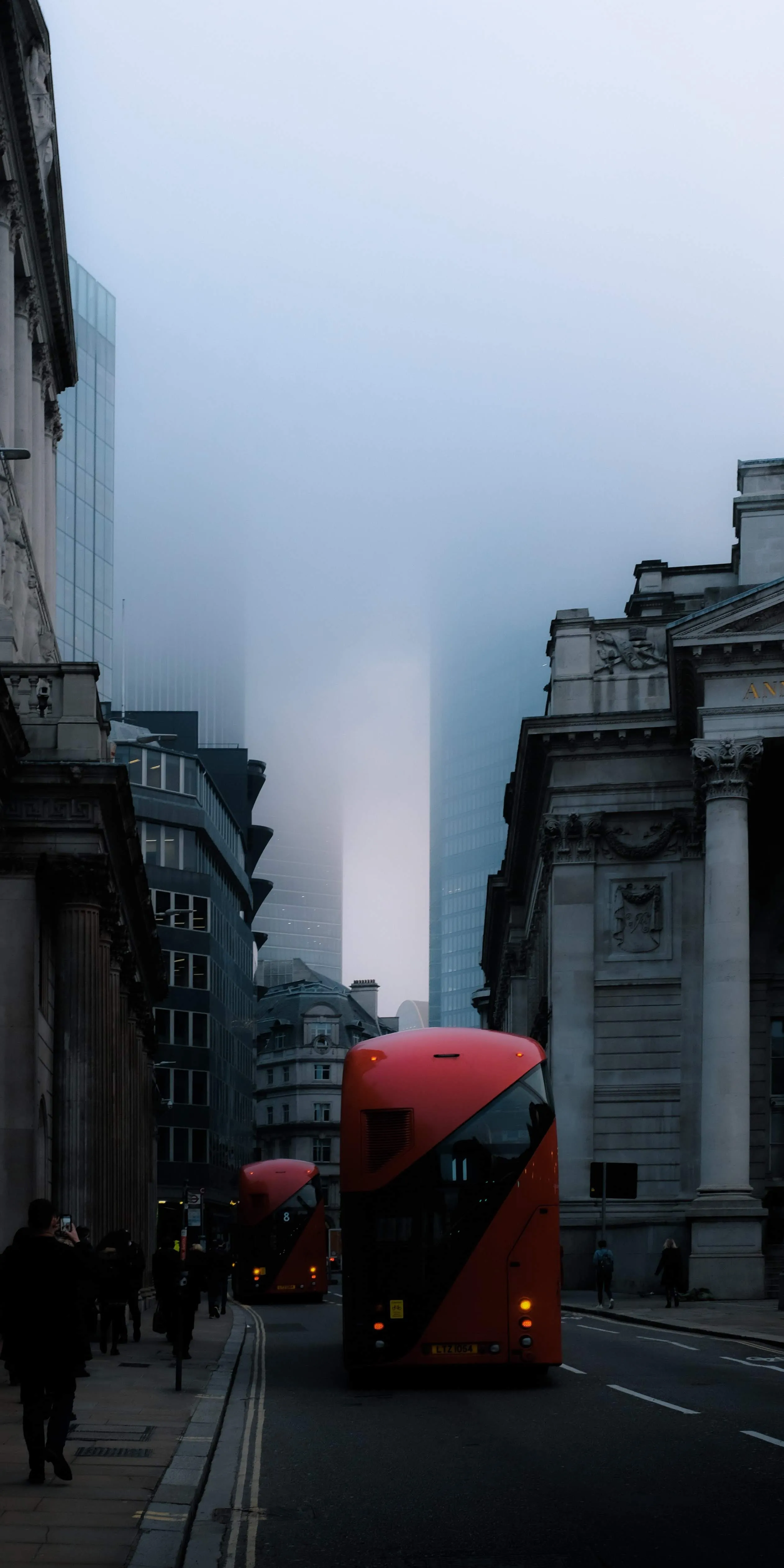 City Street Scene with Red Double Decker Bus and Tall Buildings