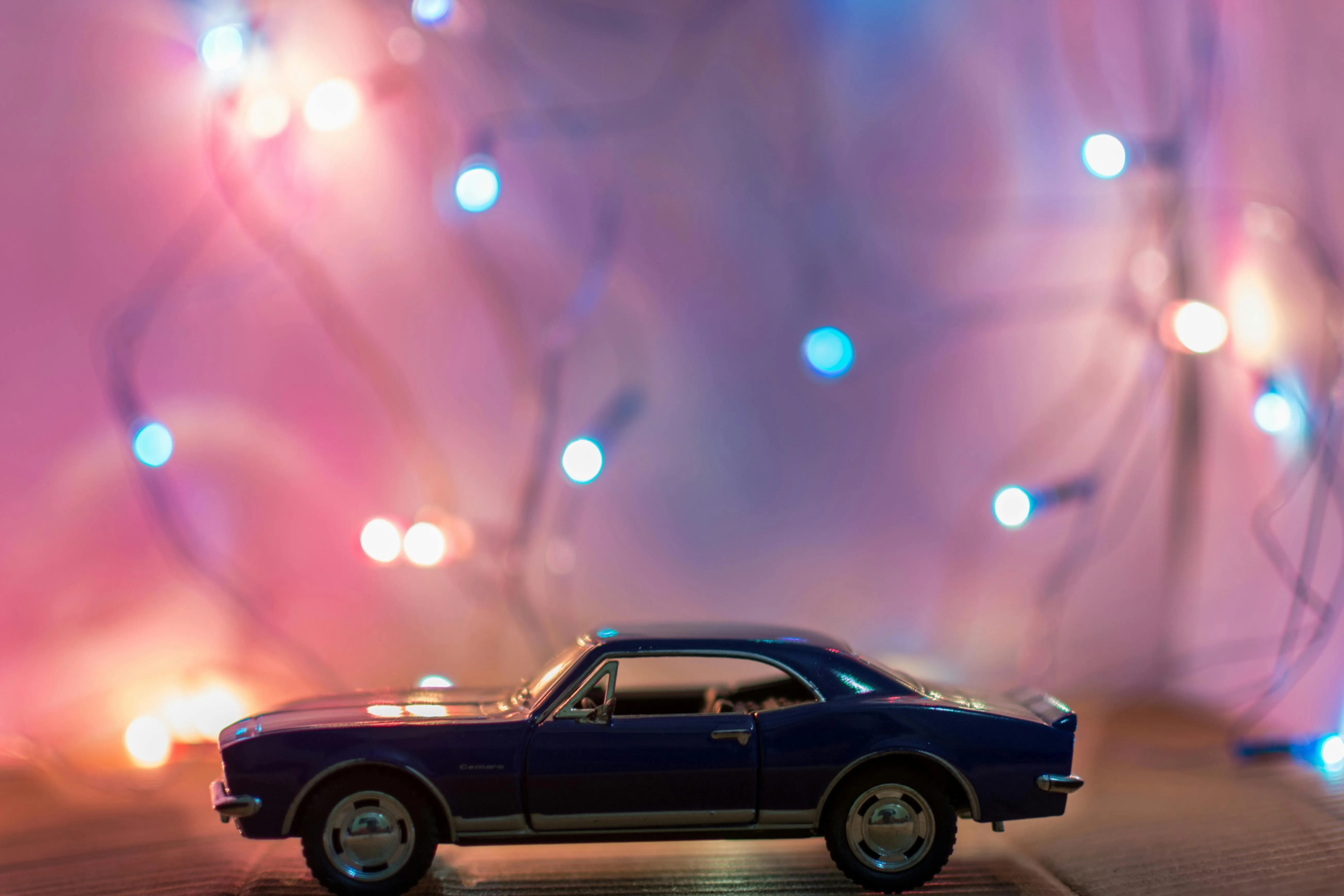 Classic toy car with blurred colourful lights background