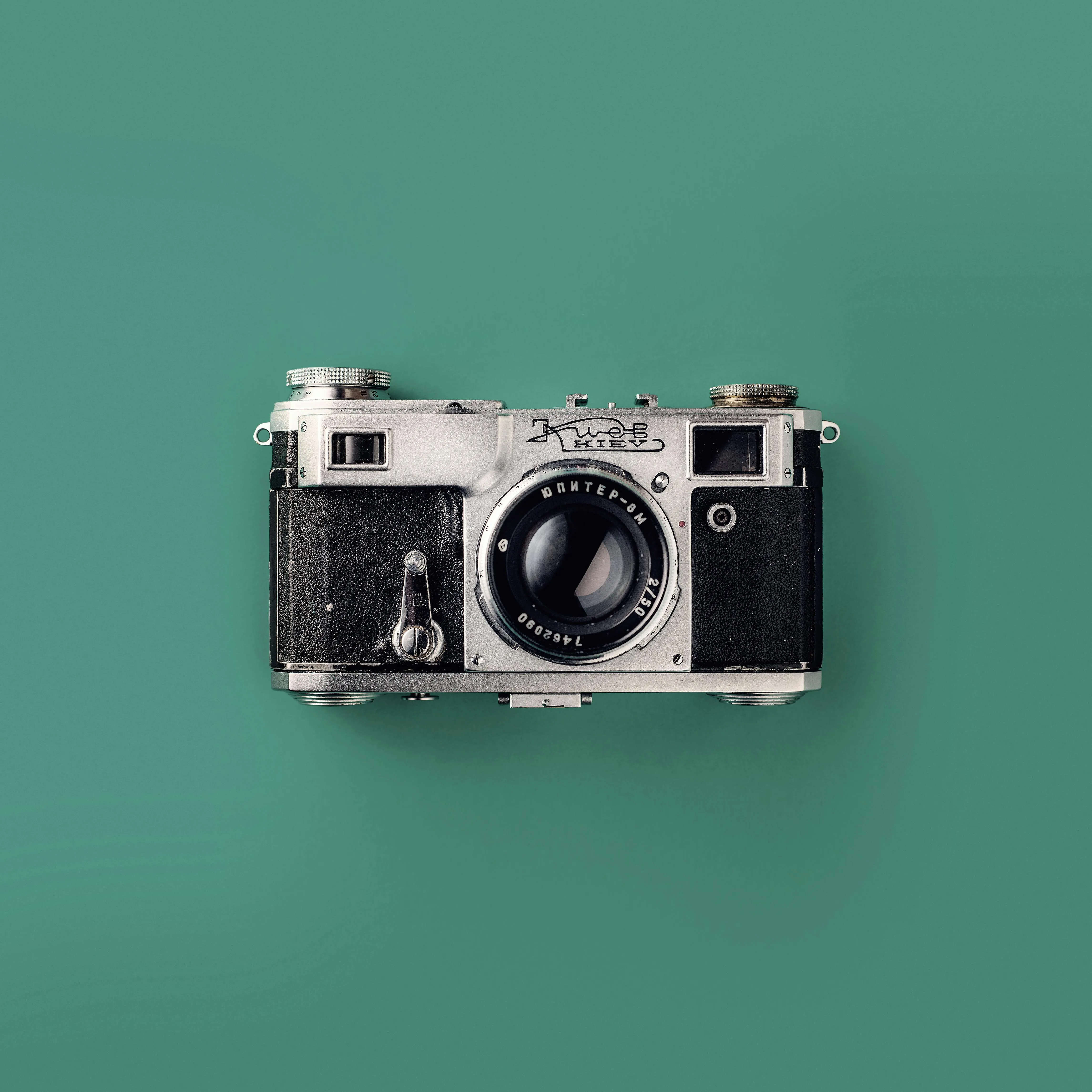 Classic vintage camera on a pastel green surface Wallpaper