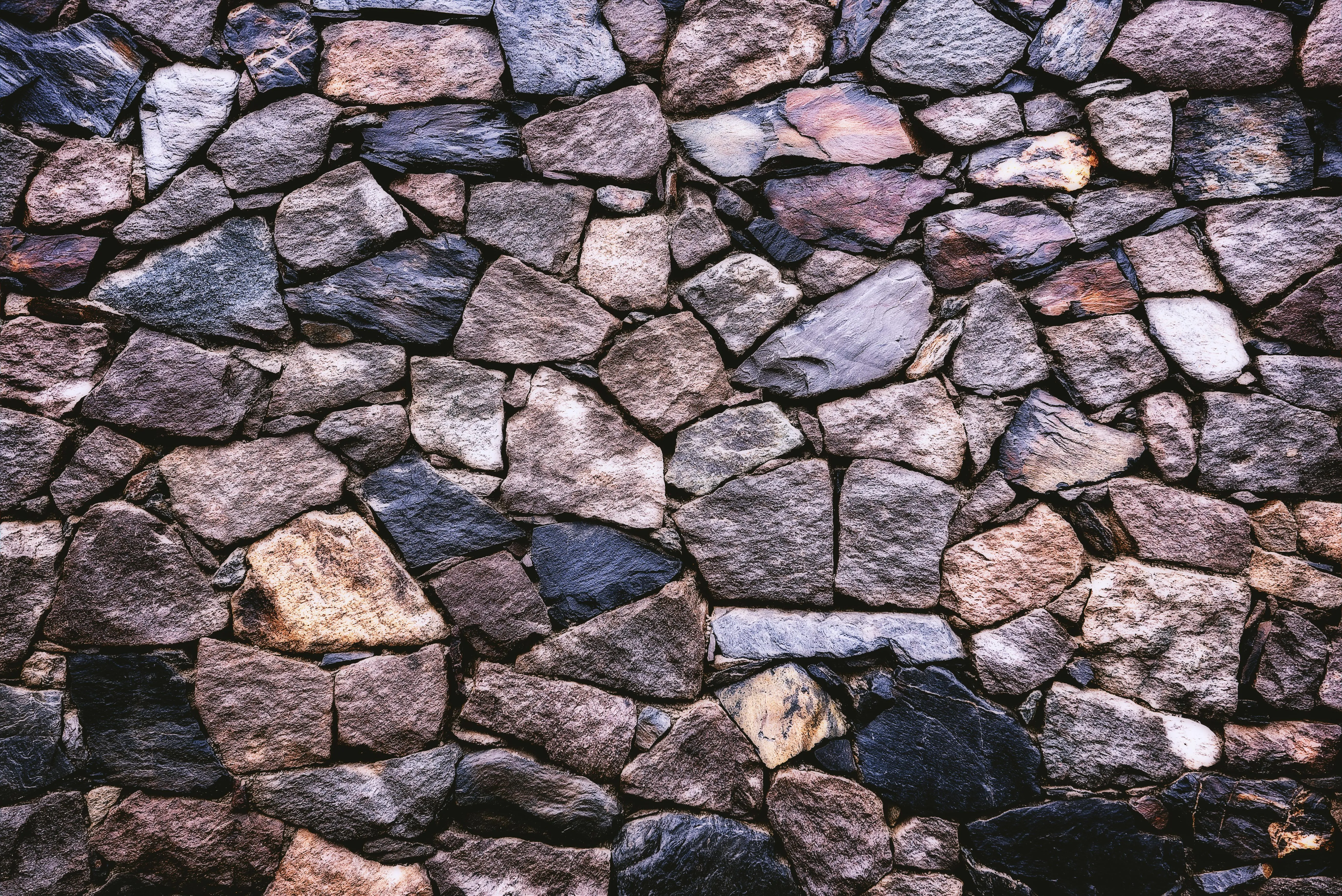Close up of a rough stone wall with various sized rocks