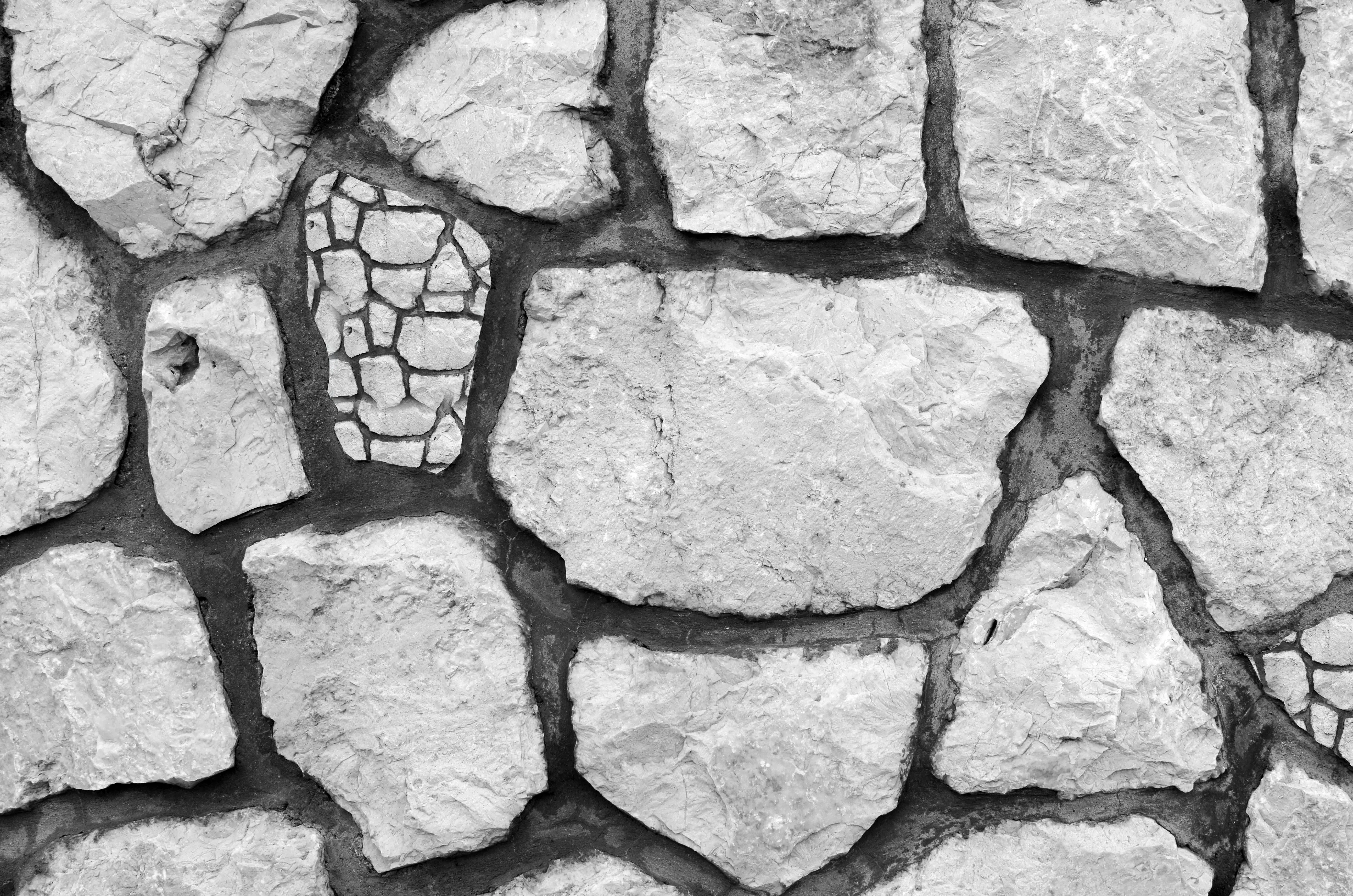 Close up of gray stone wall with irregular shaped rocks