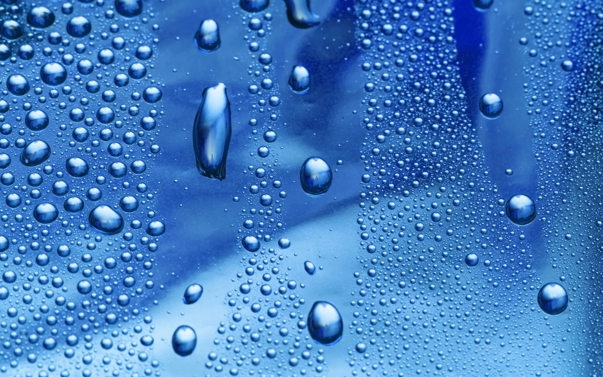 Close up water droplets on a shiny blue surface free image