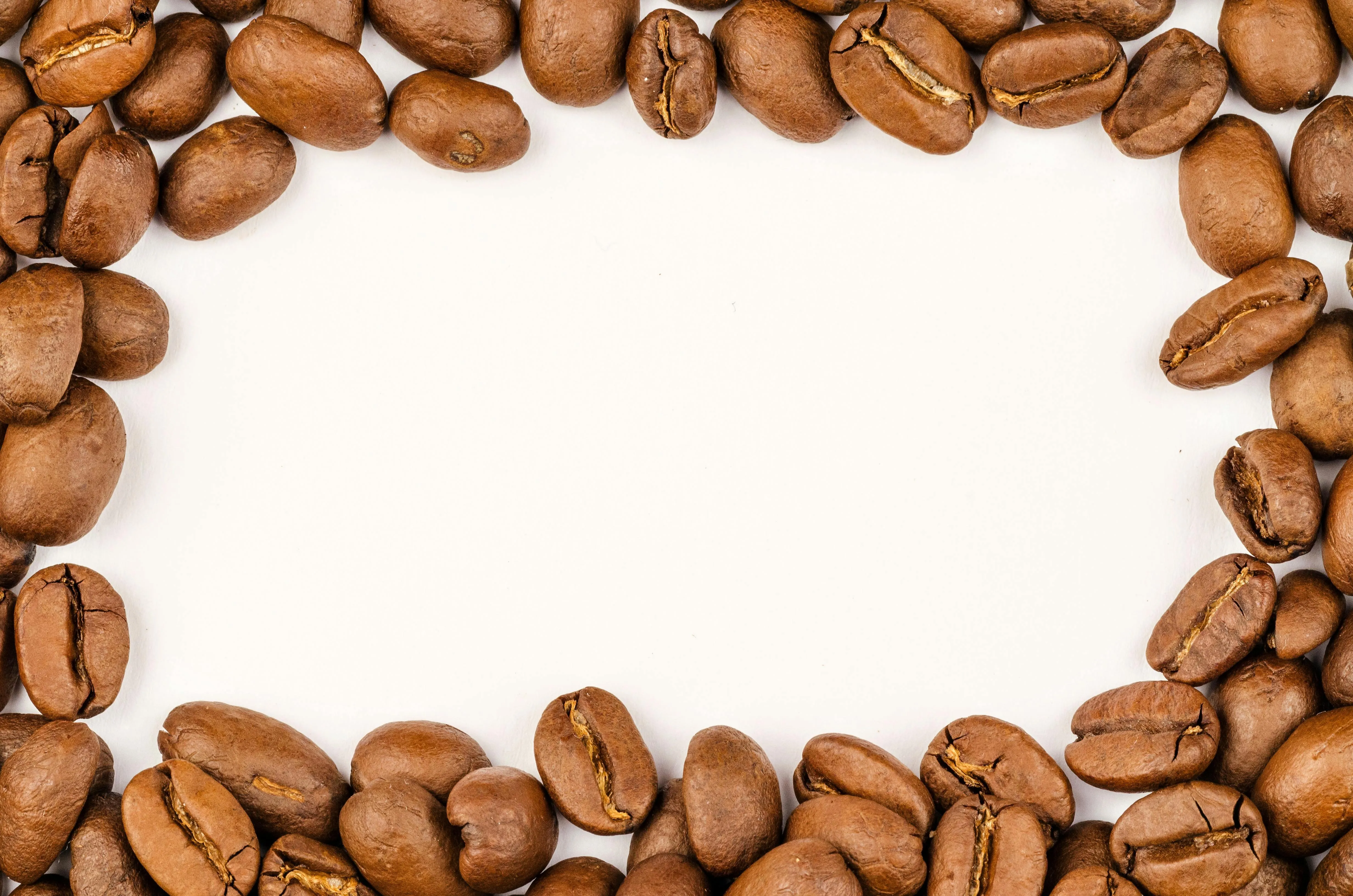Coffee beans framing a blank white space for text Wallpaper
