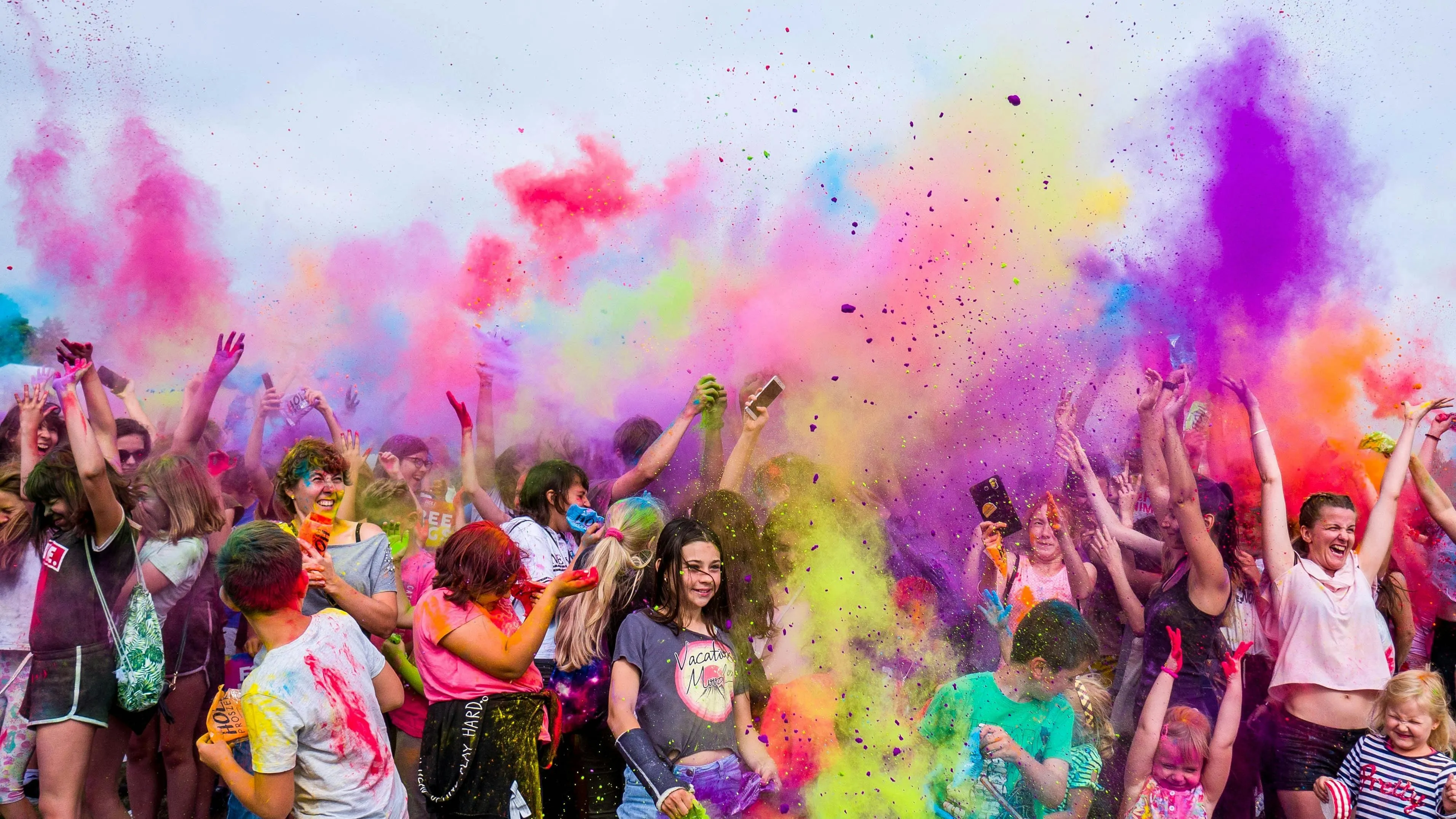 Colourful Holi festival celebration with crowd and powder