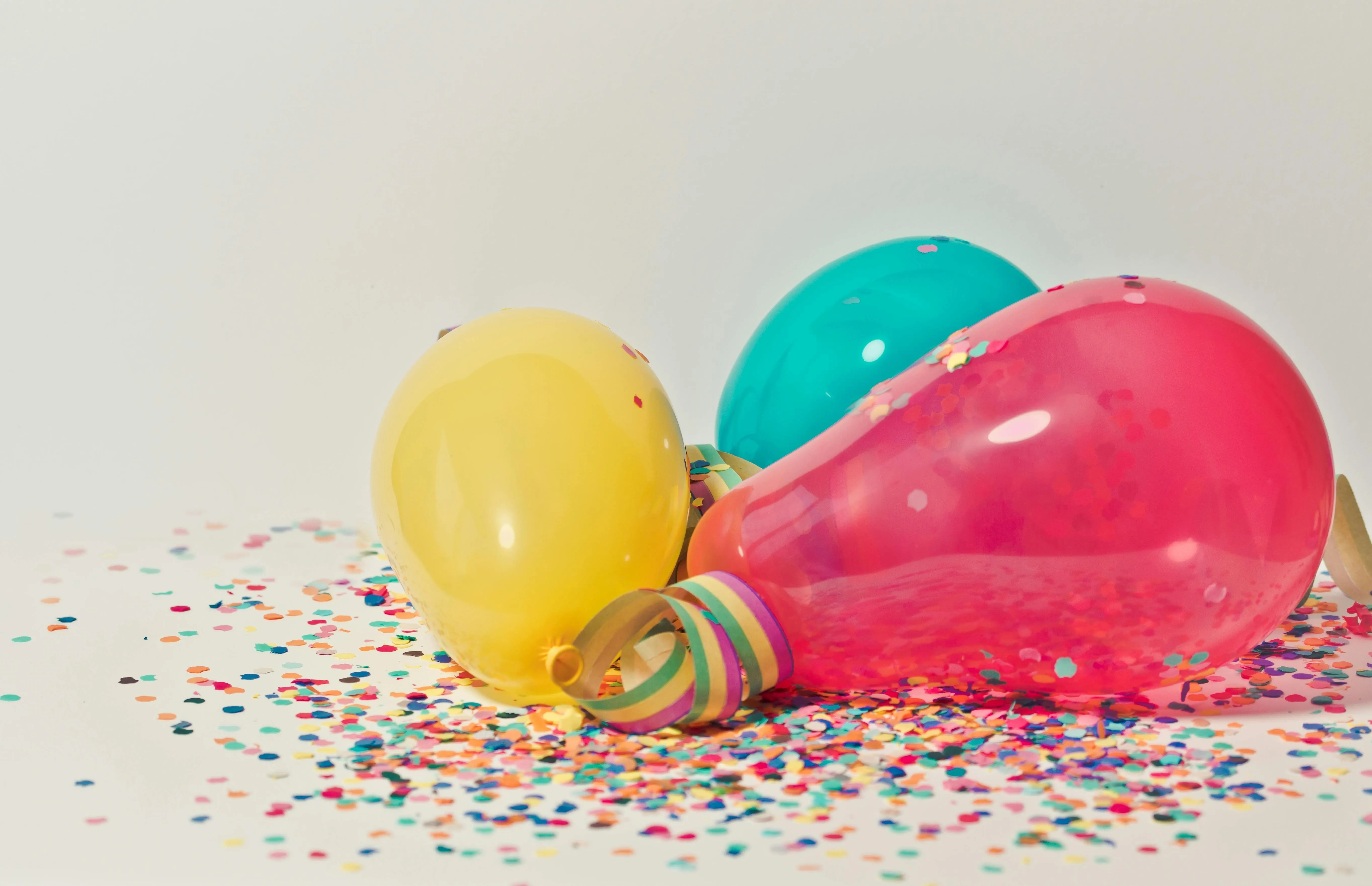Colourful light bulbs with confetti on a white surface 4K