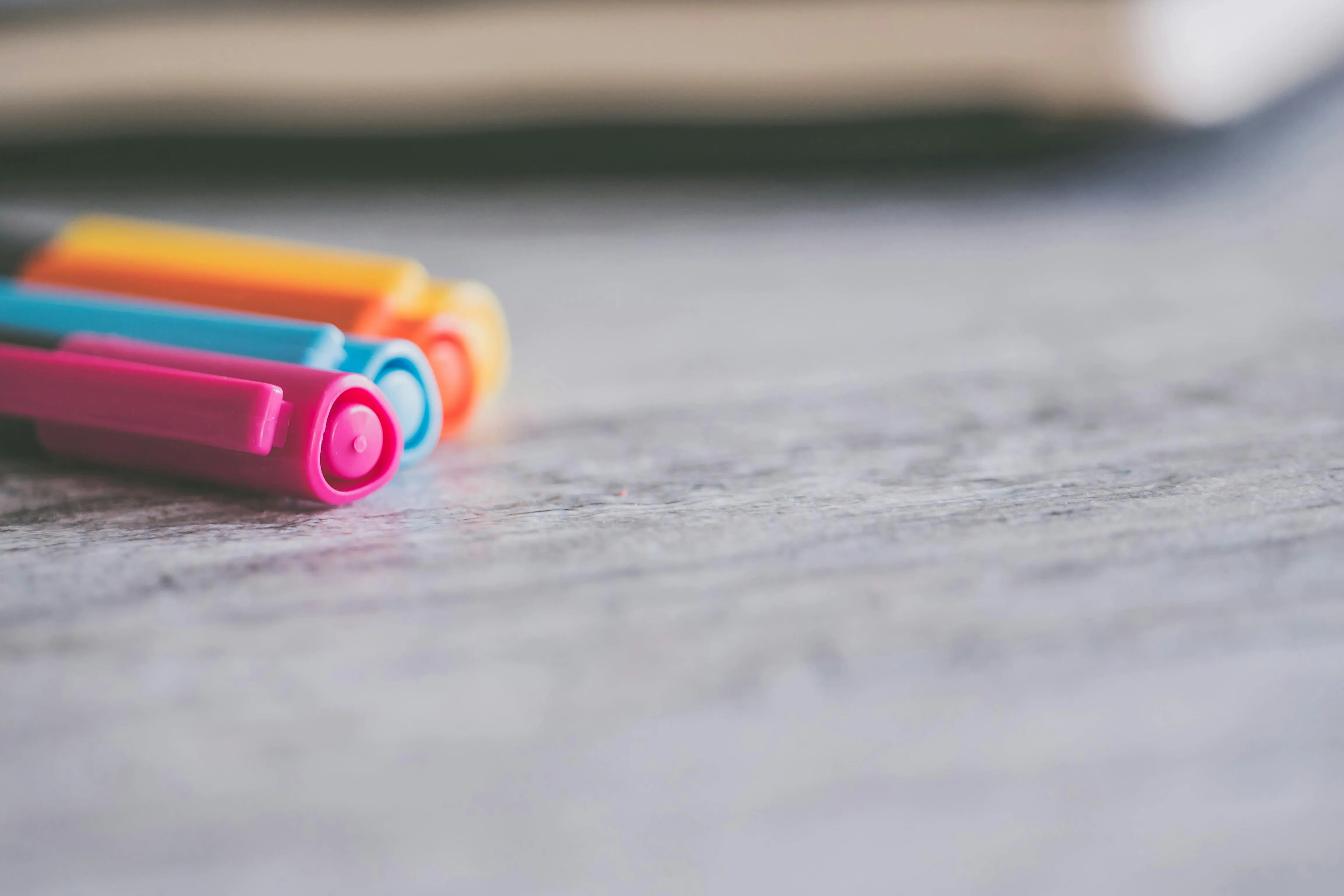 Colourful markers lying on a wooden surface 4K Wallpaper