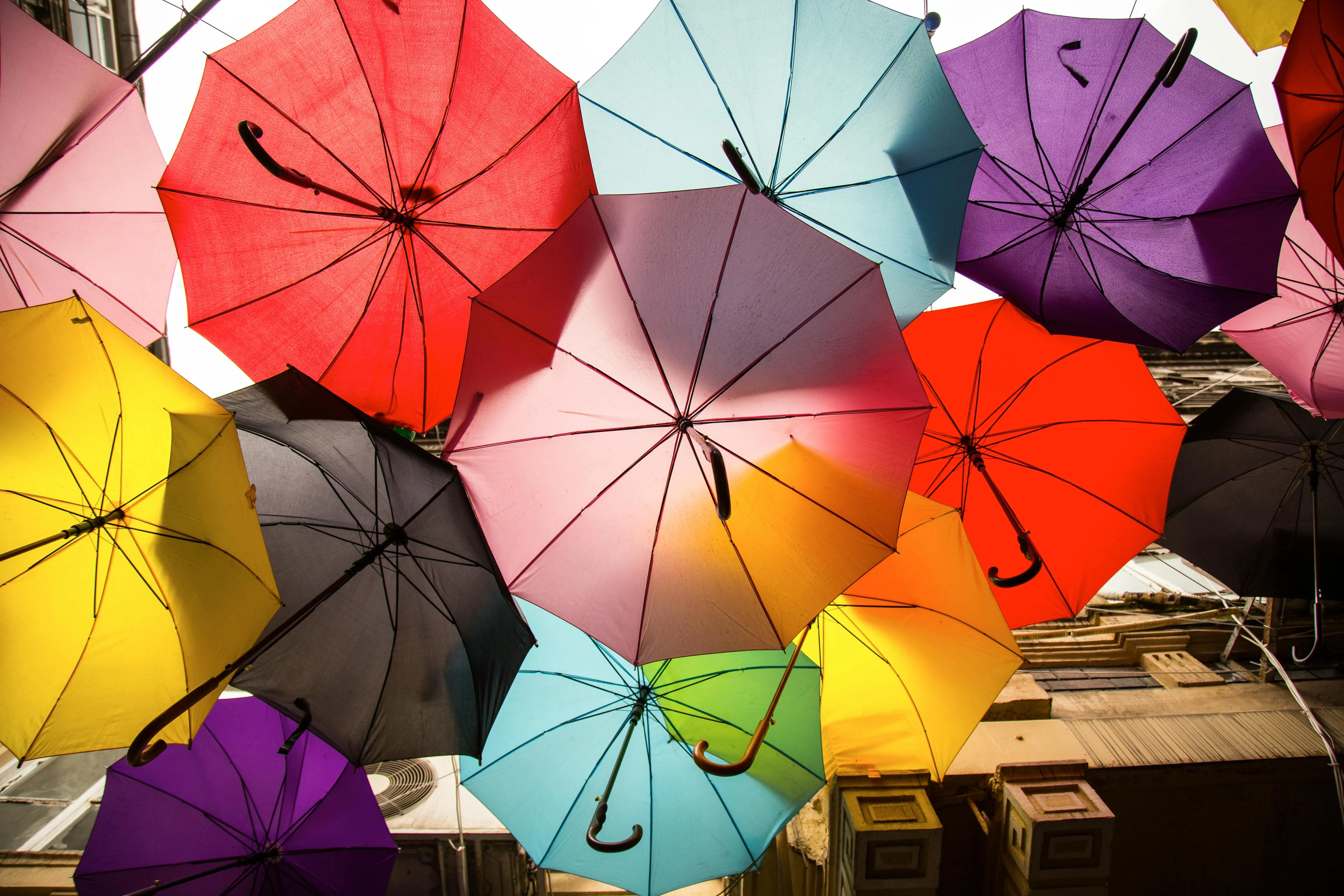 Colourful umbrellas hanging above a lively street view image