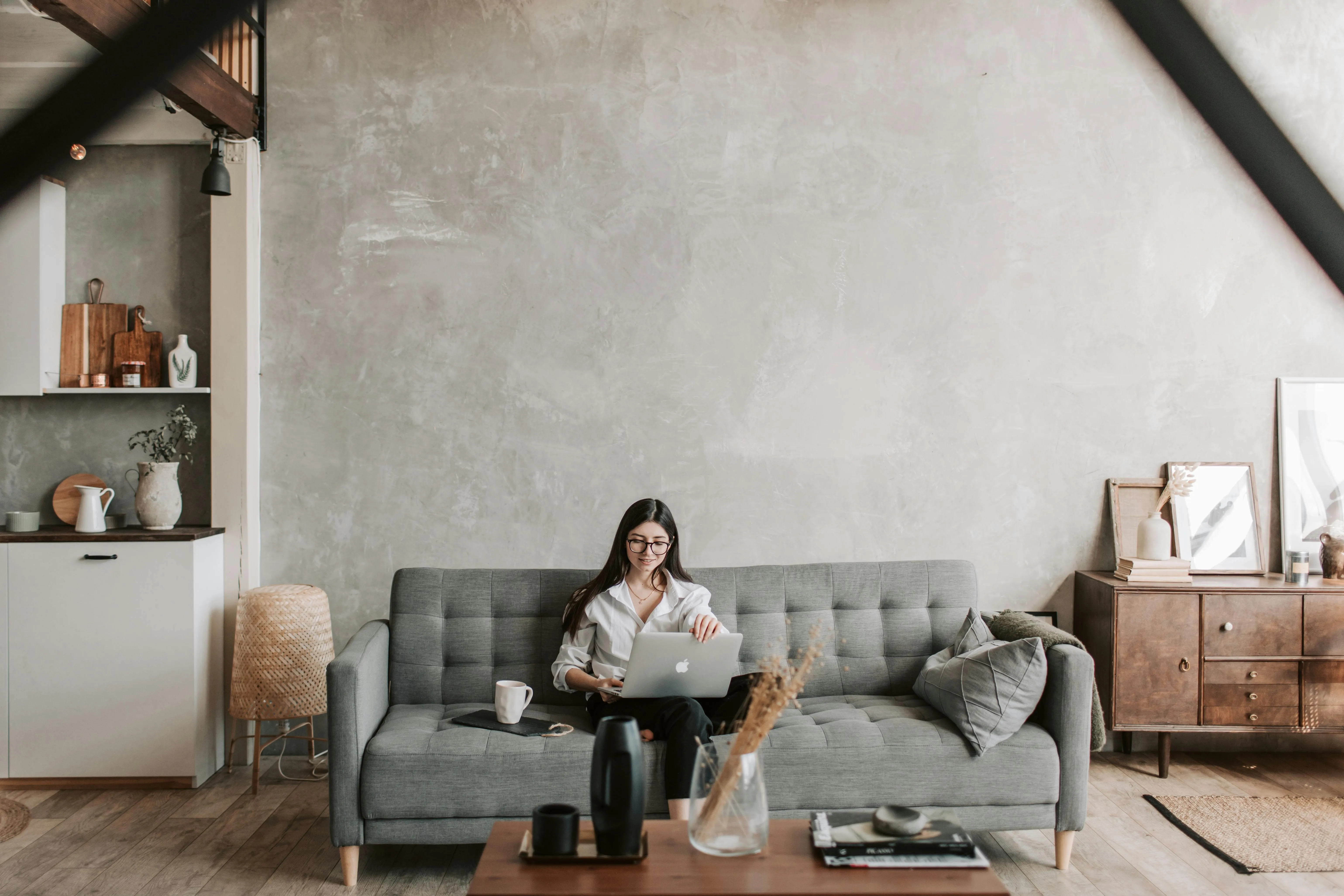 Cozy modern living room with woman working on laptop image