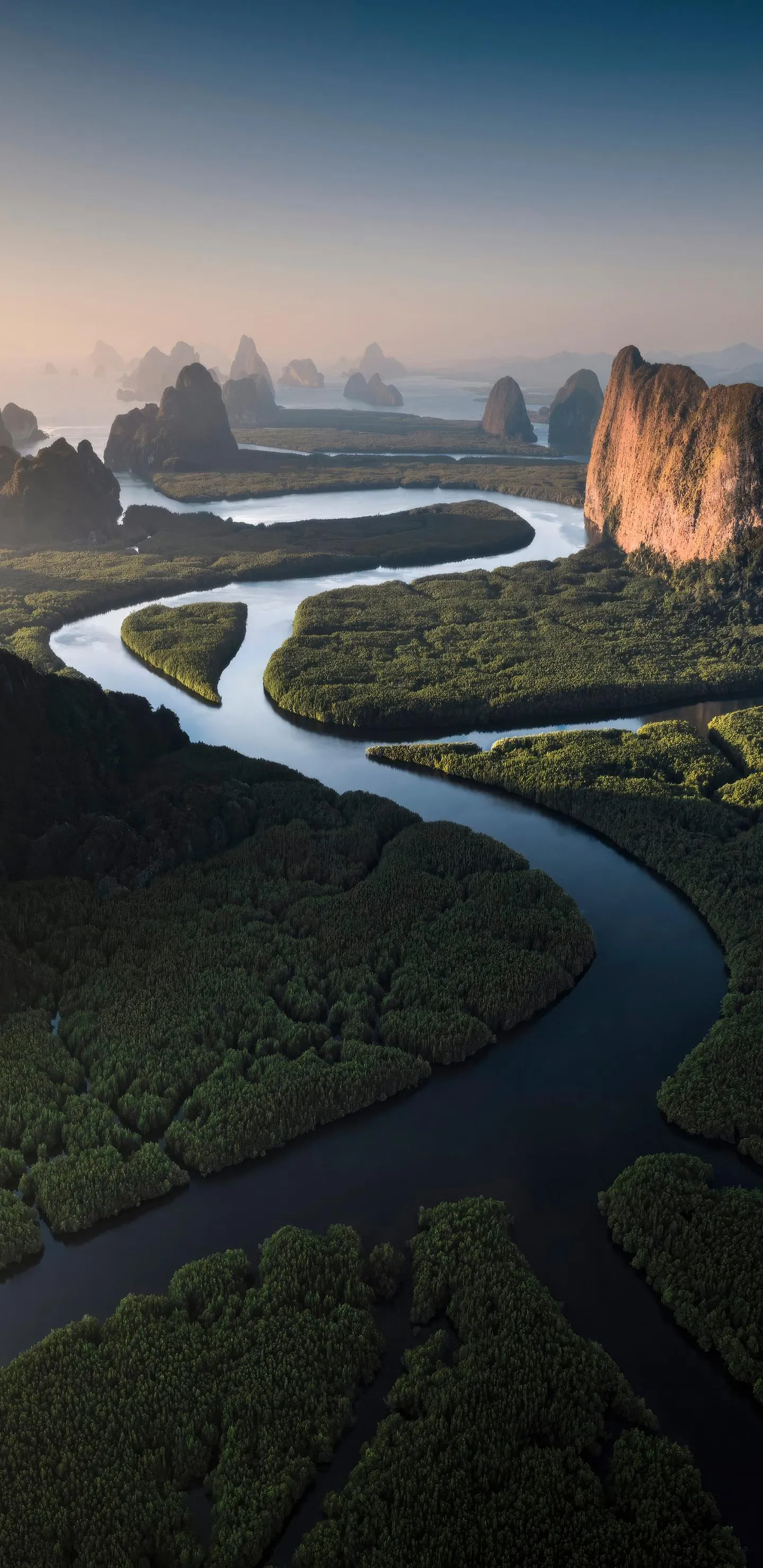 Curved River Through Green Valley Under Soft Light Sky