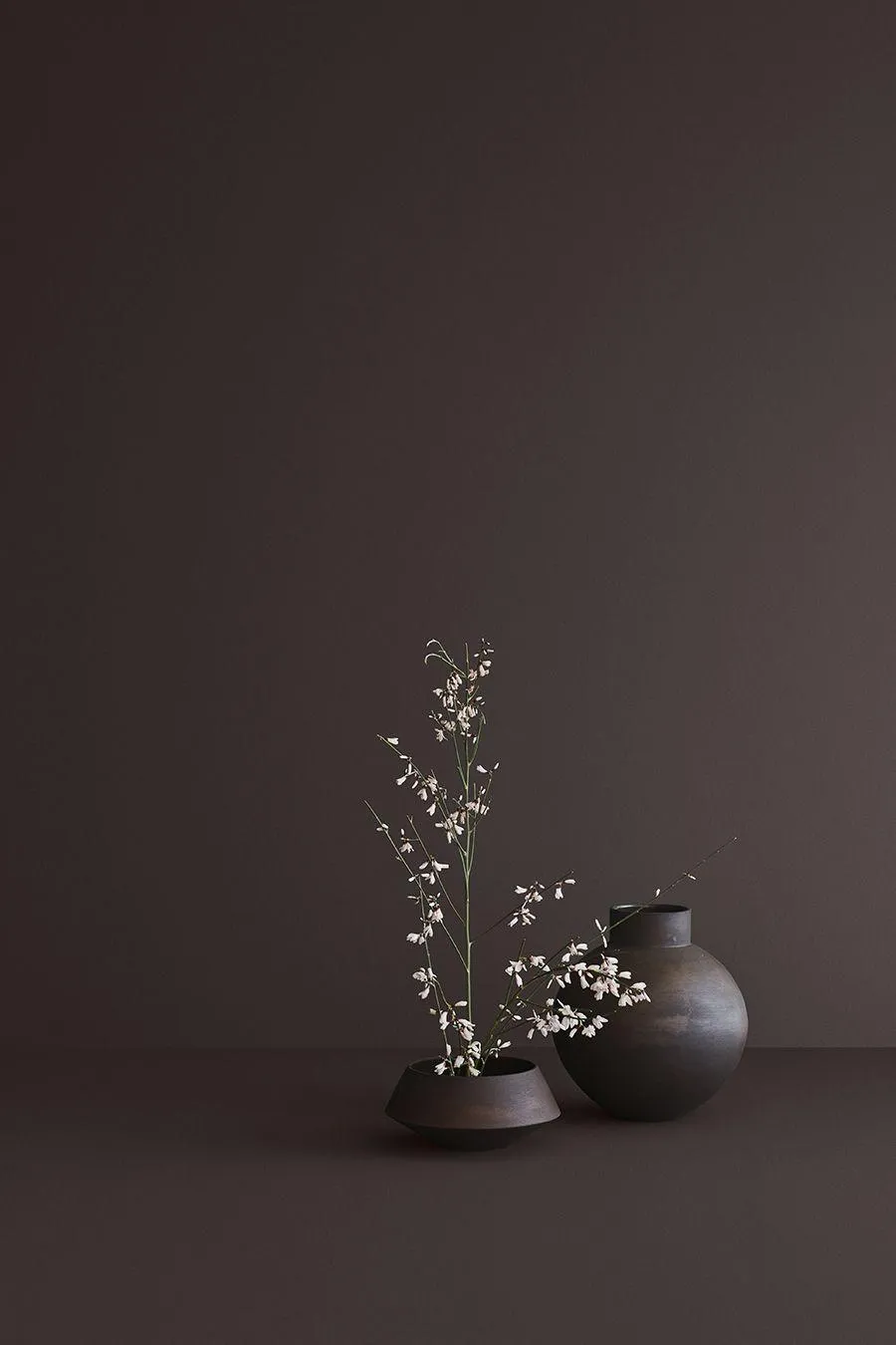 Dark brown background with minimal ceramic vase decoration