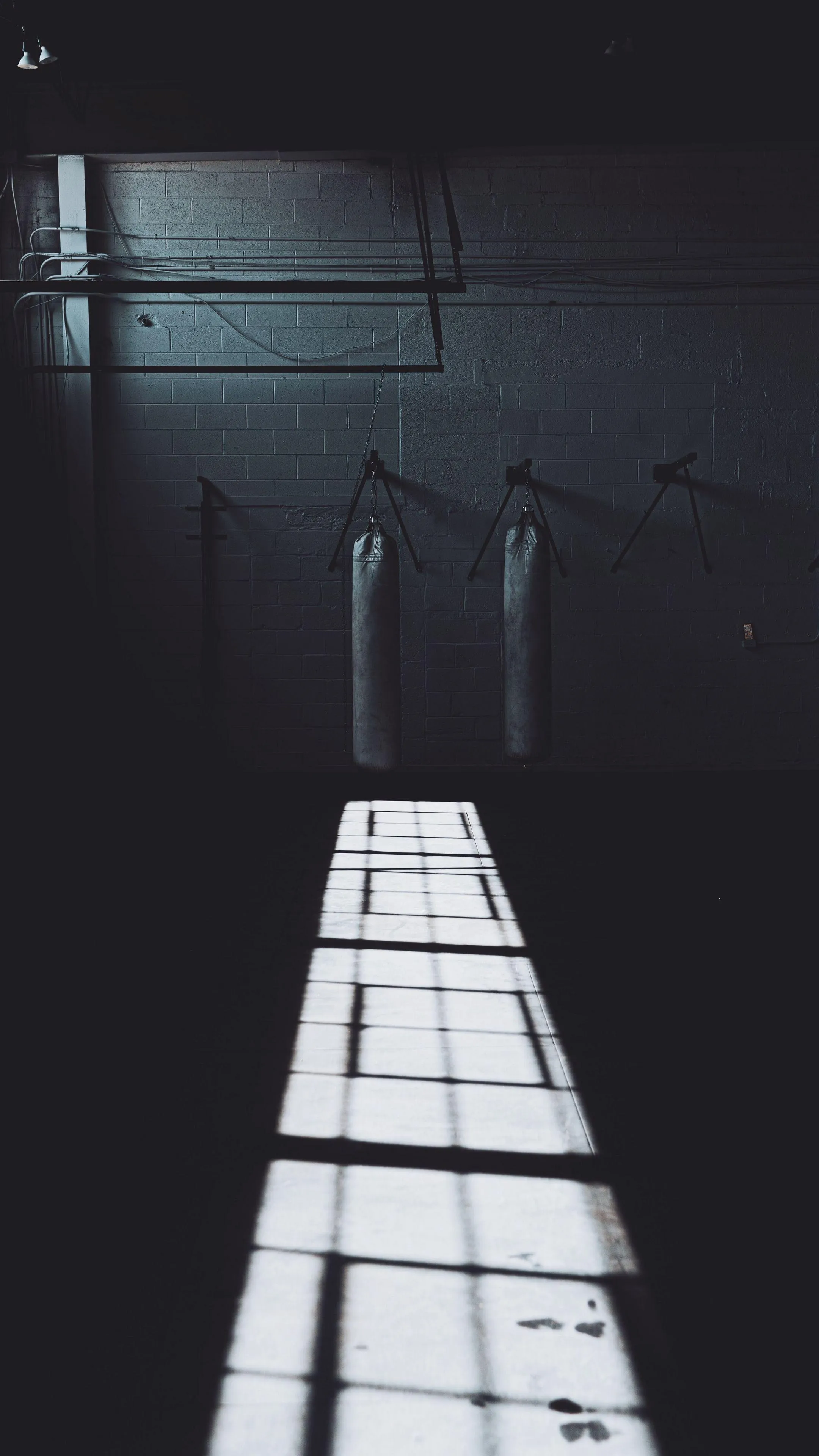 Dark corridor with light shining through open door Wallpaper