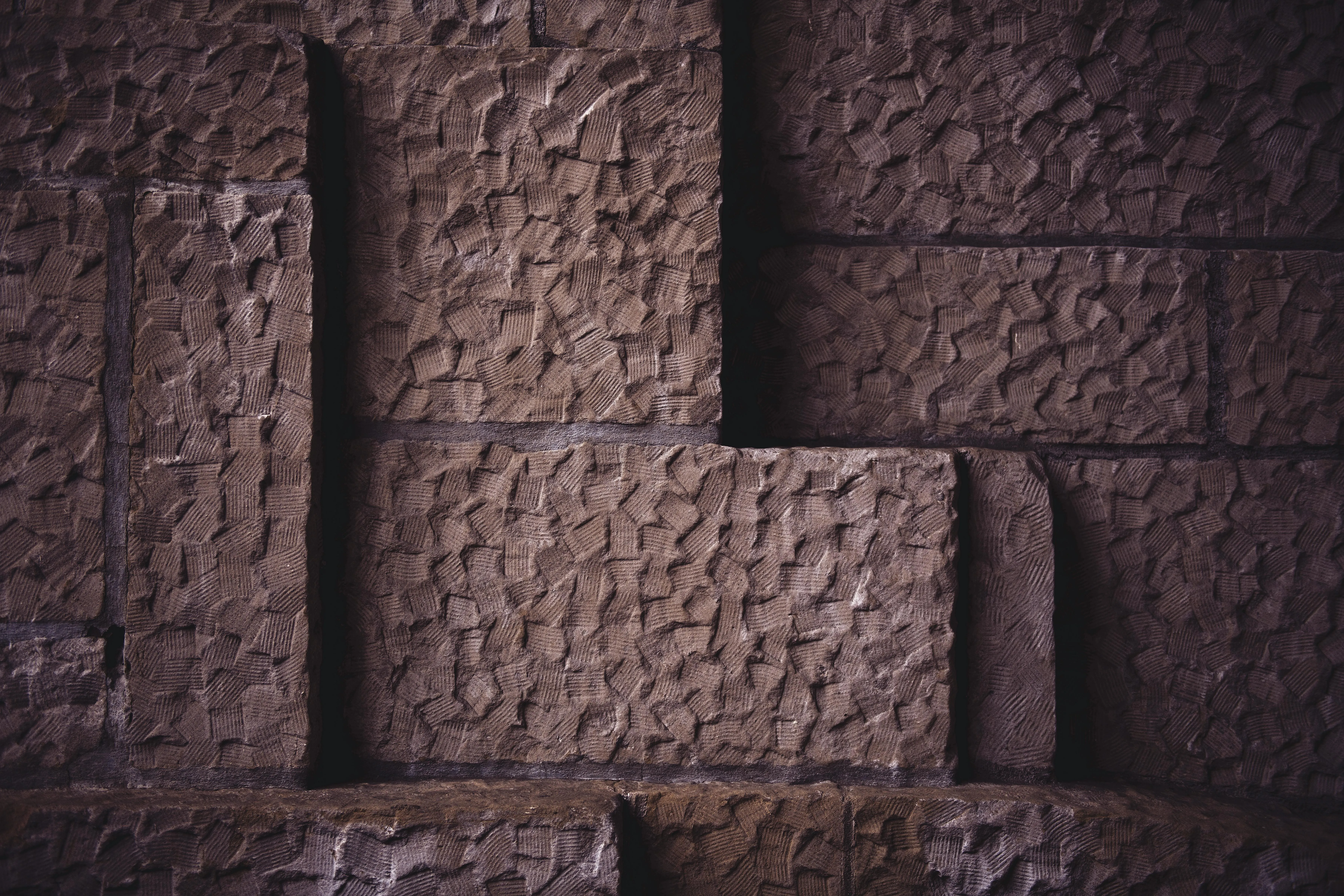 Dark textured stone blocks forming a geometric pattern image