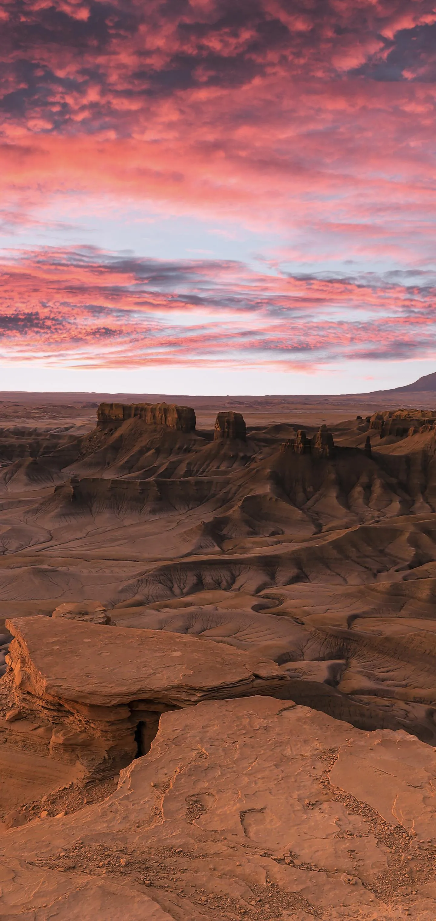 Dramatic Sky with Pink Clouds Over Rocky Desert Wallpaper