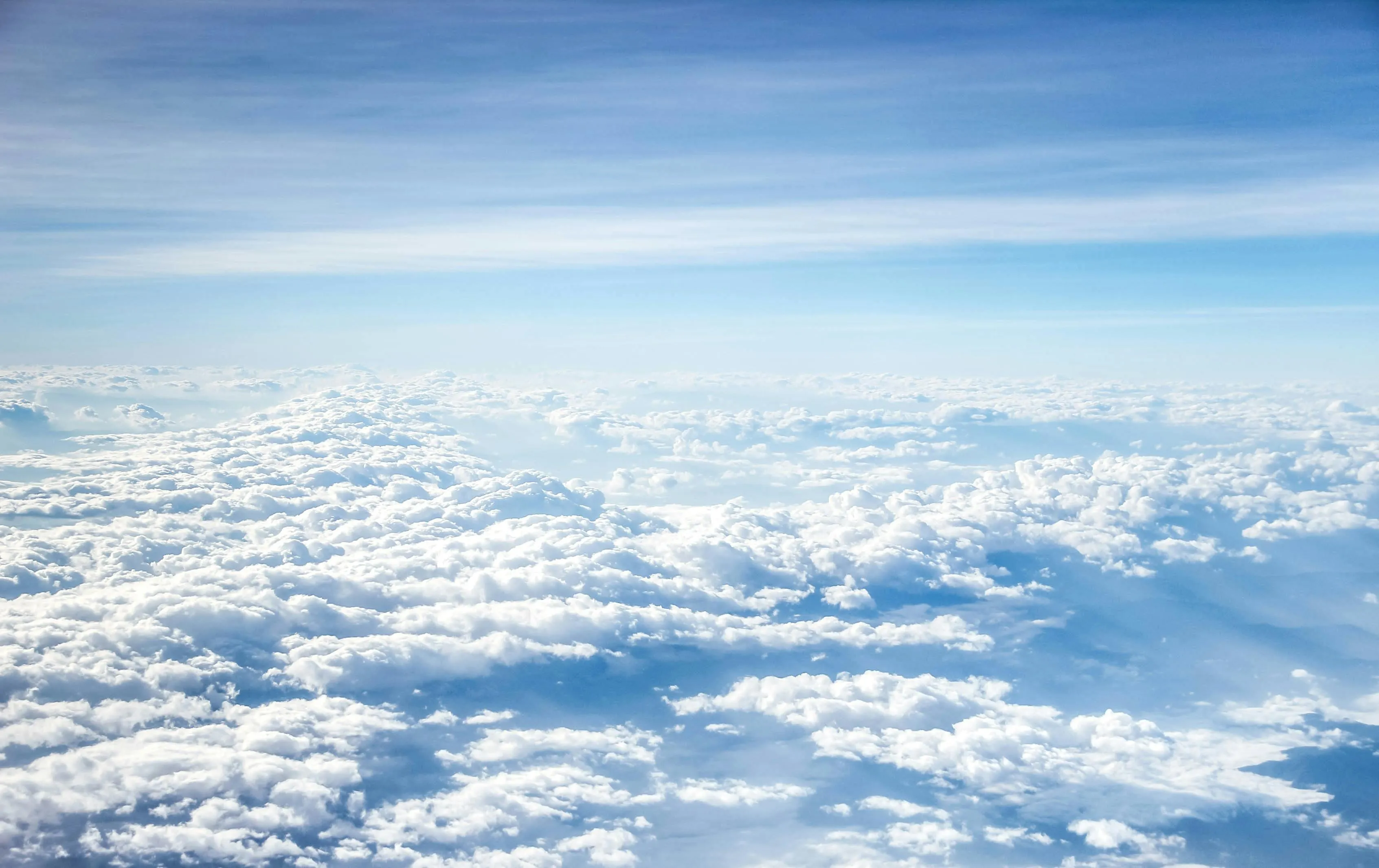 Fluffy white clouds under a clear a blue sky HD Wallpaper