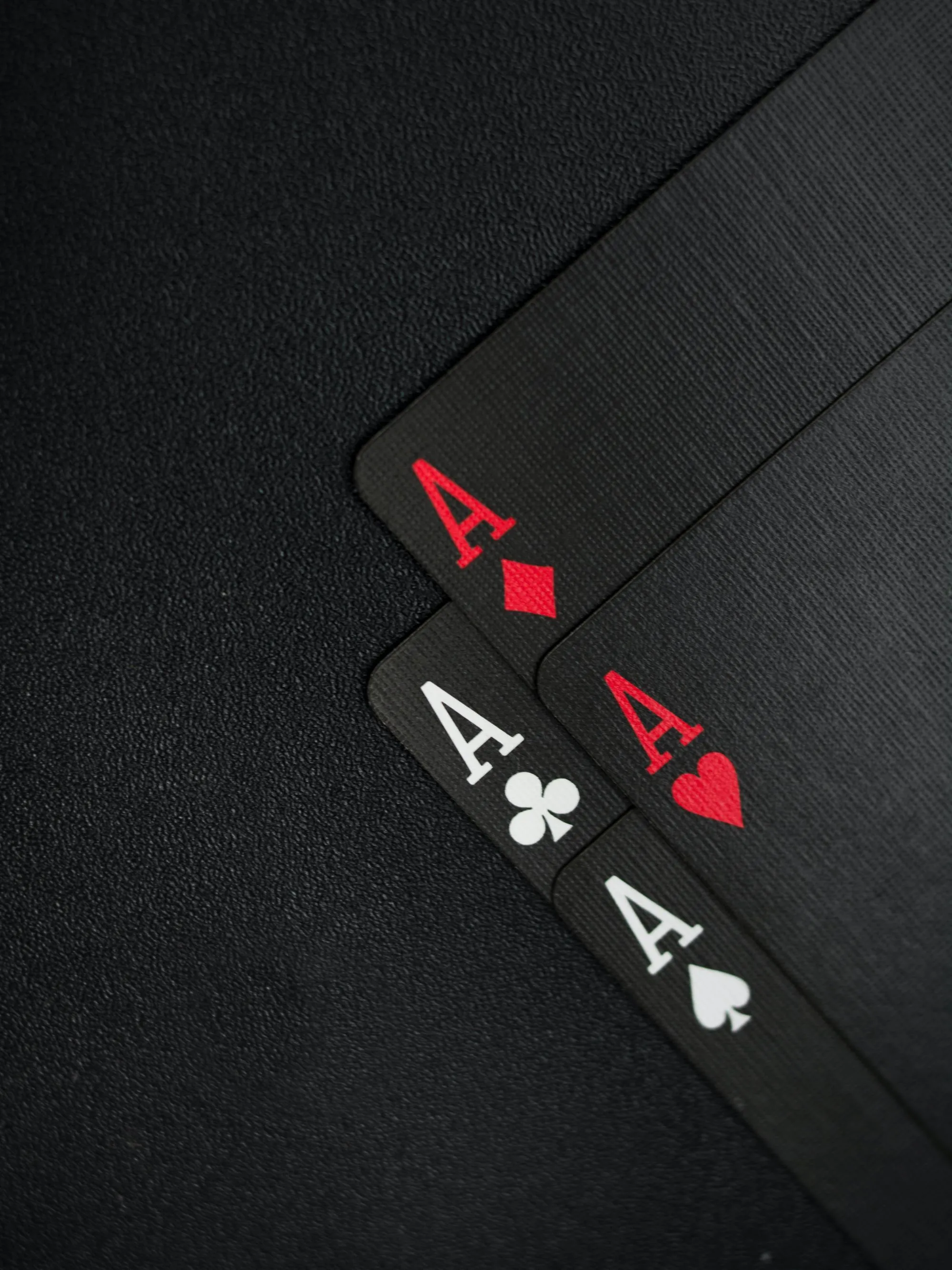 Four Aces Displayed on Elegant Black Textured Card Table