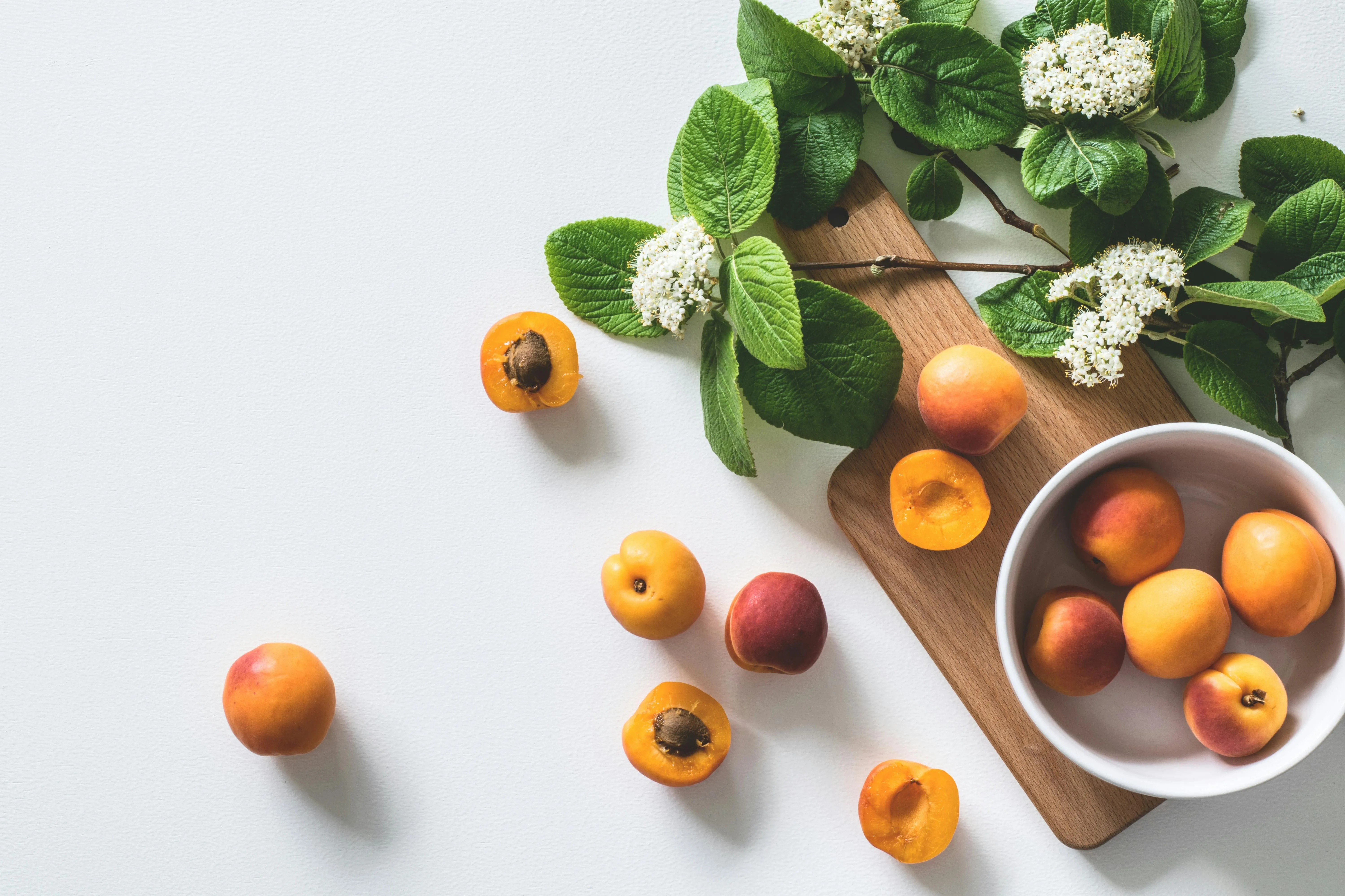 Fresh apricots with green leaves on a white background HD