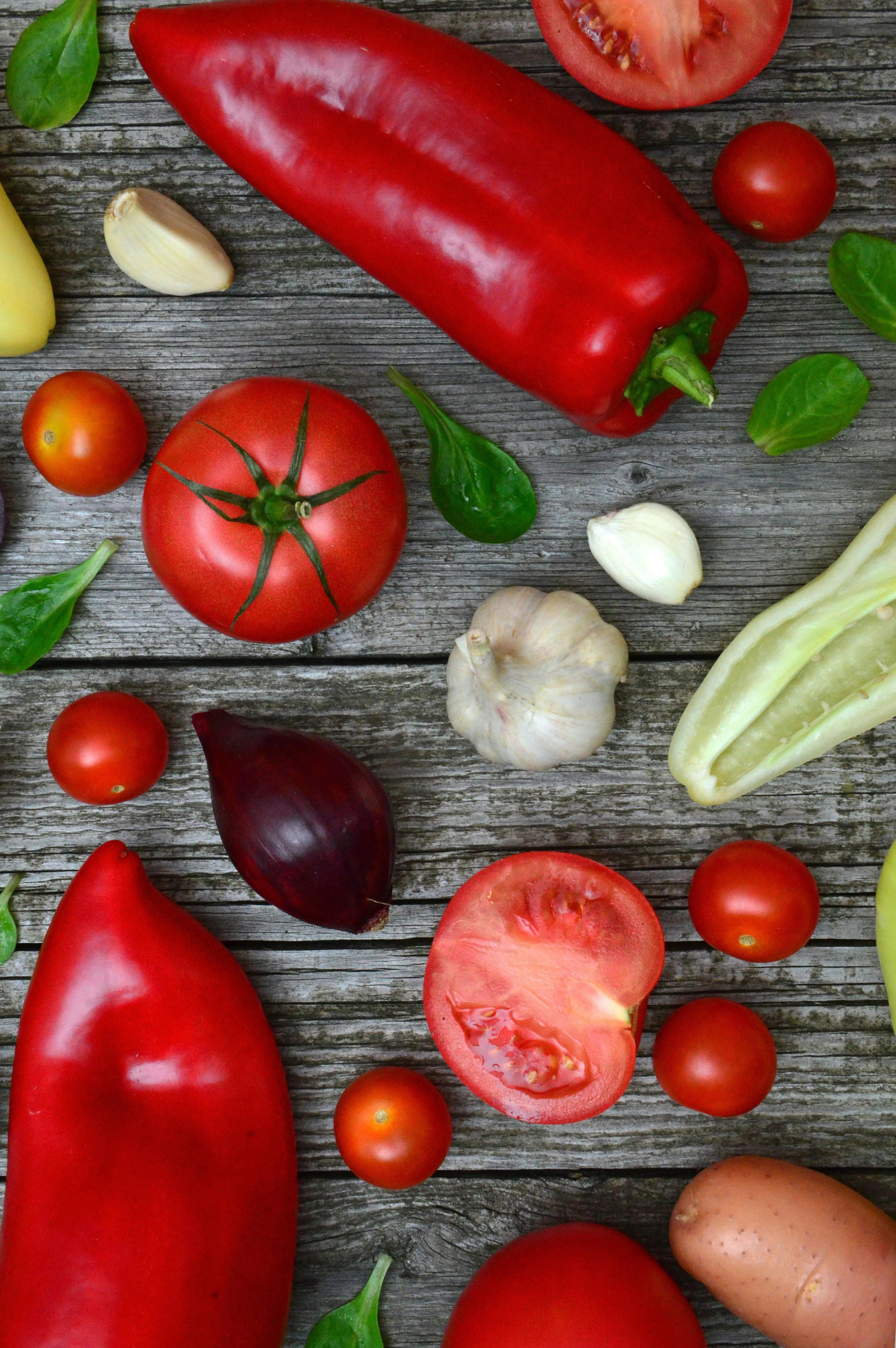 Fresh red peppers and tomatoes on rustic wooden surface