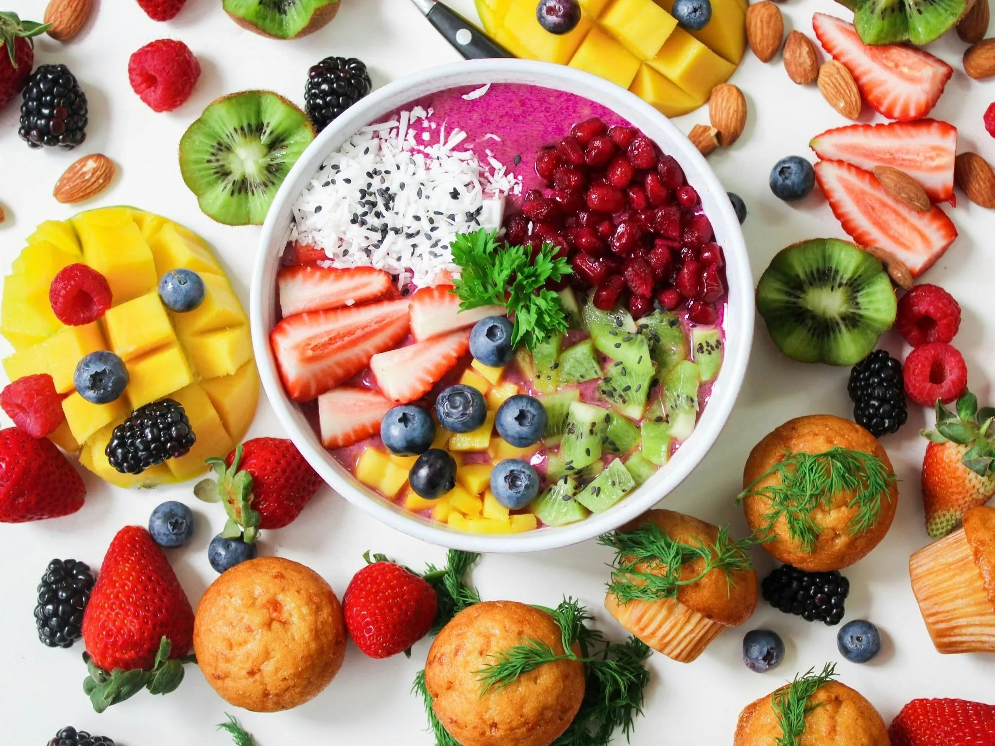 Fresh vibrant smoothie bowl surrounded by healthy fruits