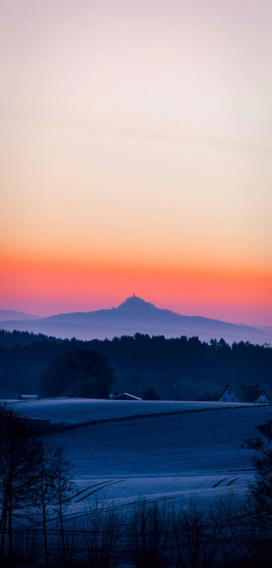 Gradient Sunset Casting Light Over Calm Mountain Silhouettes