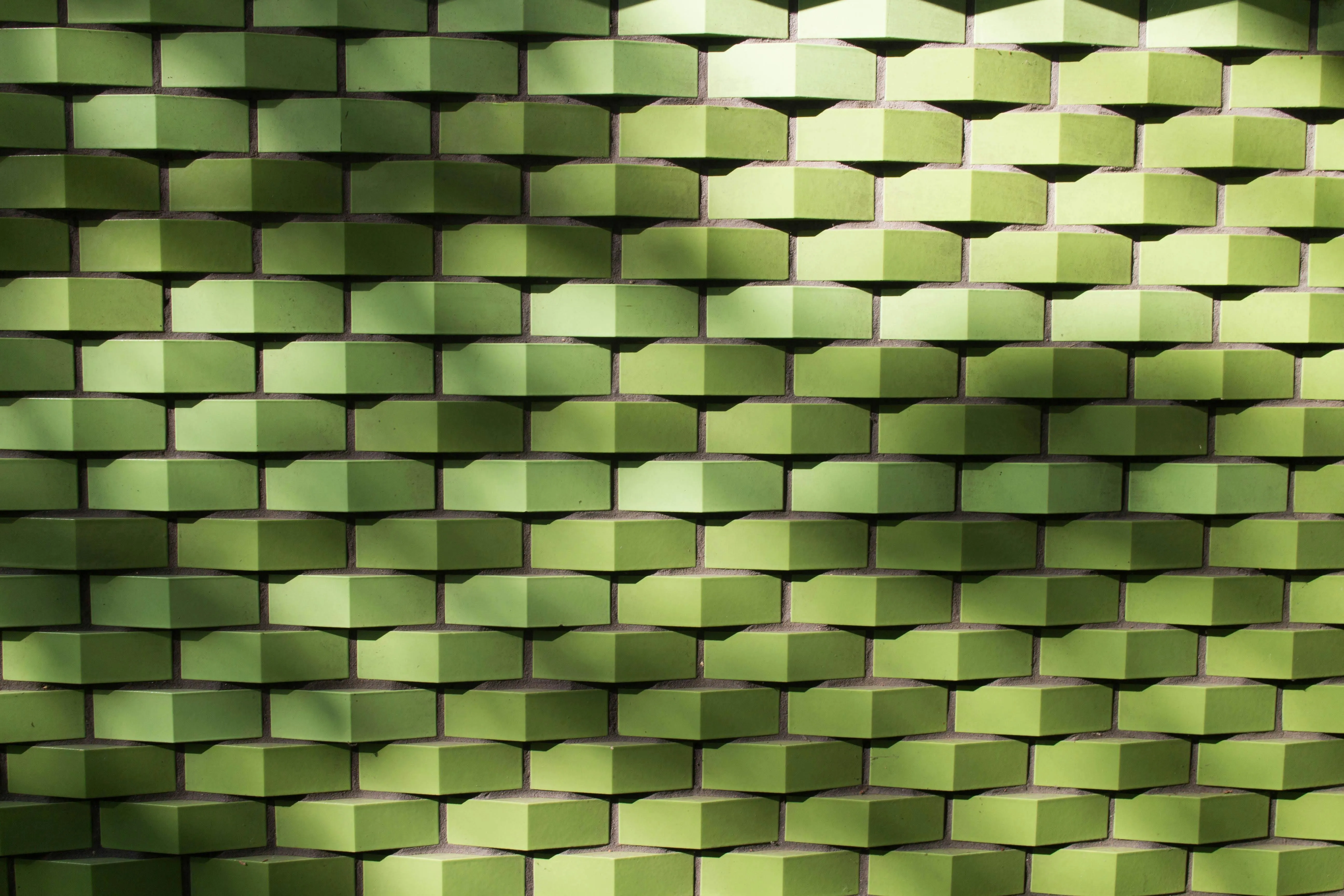 Green brick wall with a modern geometric pattern Wallpaper
