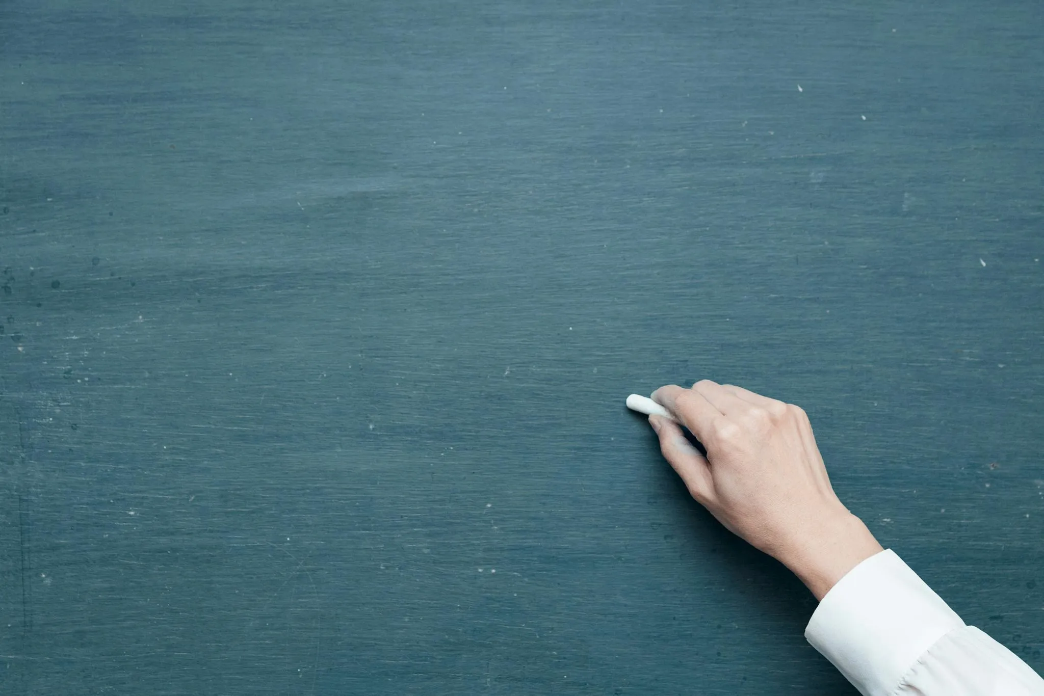 Hand on chalkboard with empty dark background space 4K image