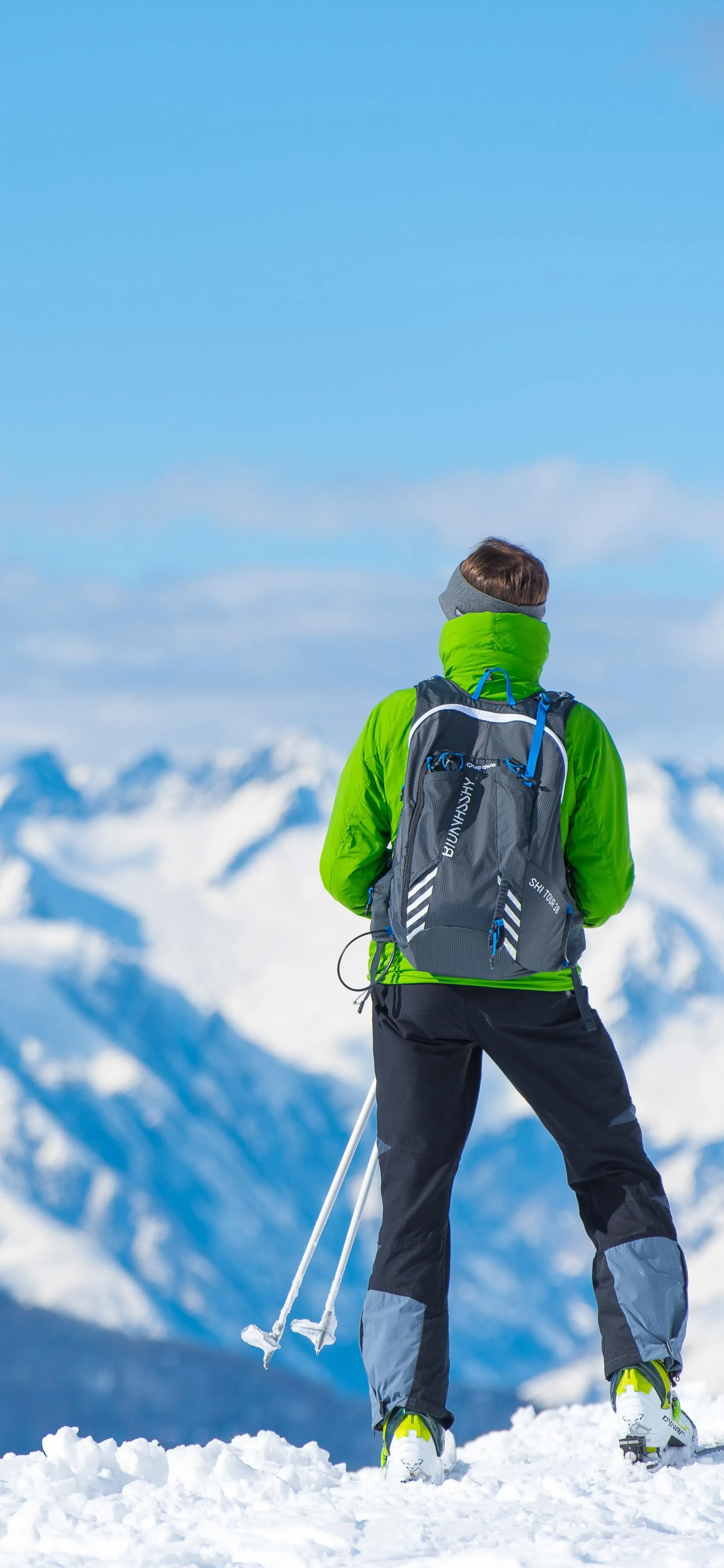 Man Standing on Snowy Mountain Wearing Green Jacket