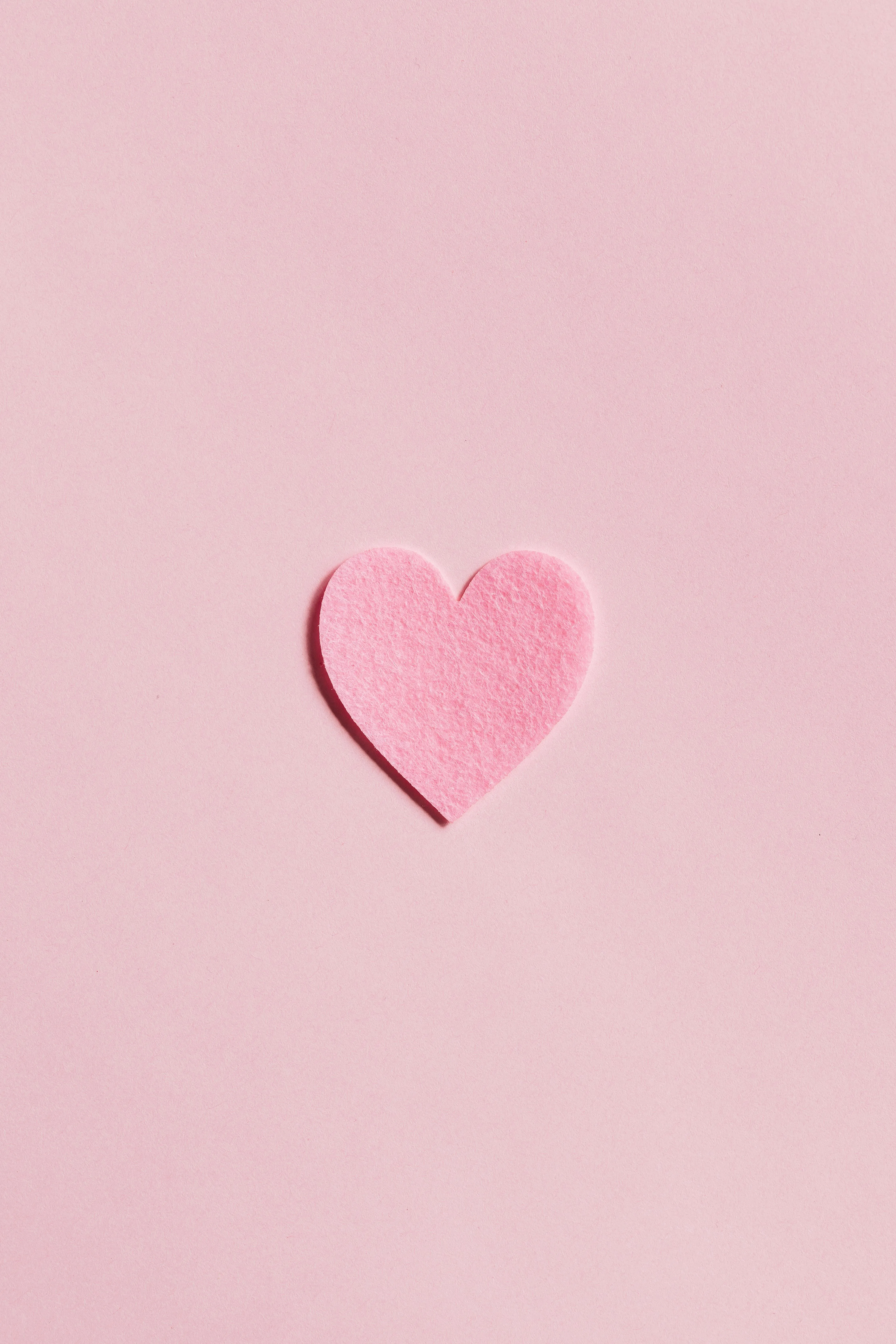 Minimal pink background with a heart at the center Wallpaper
