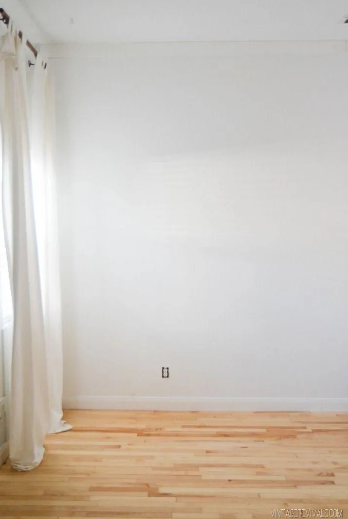 Minimalist empty white room with wooden flooring and light