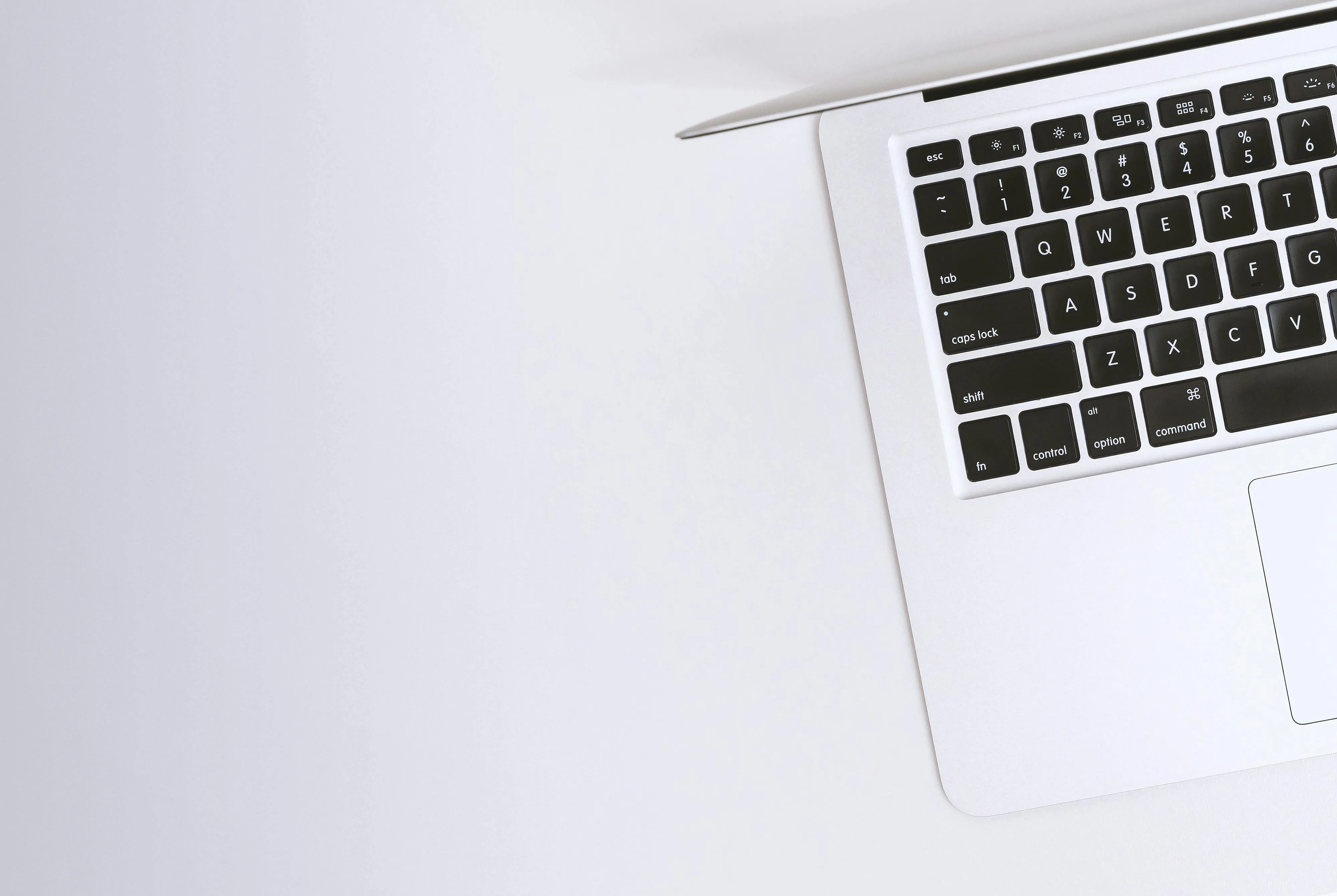 Minimalist laptop corner on a clean white surface background