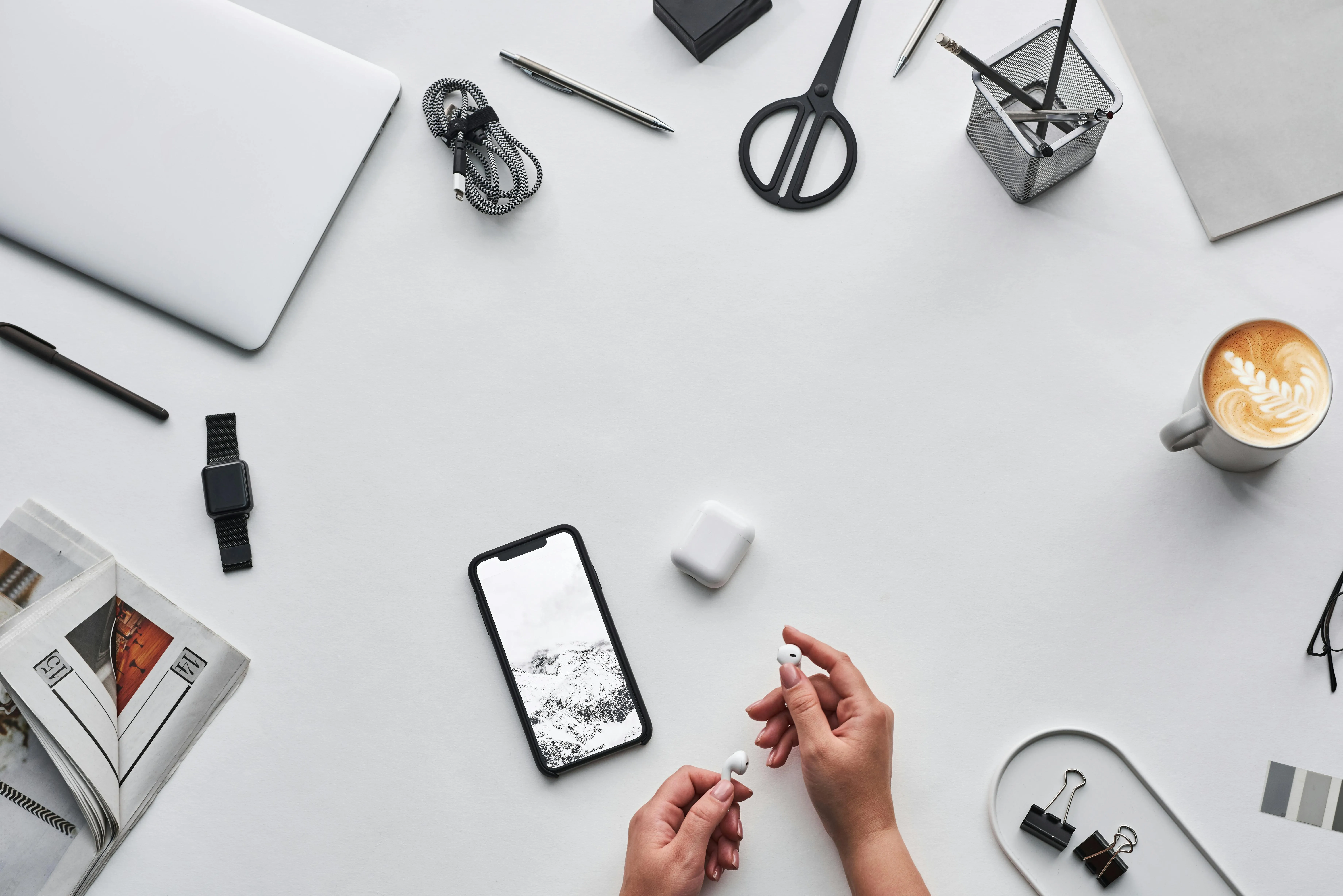 Modern white workspace with tech gadgets and coffee on desk