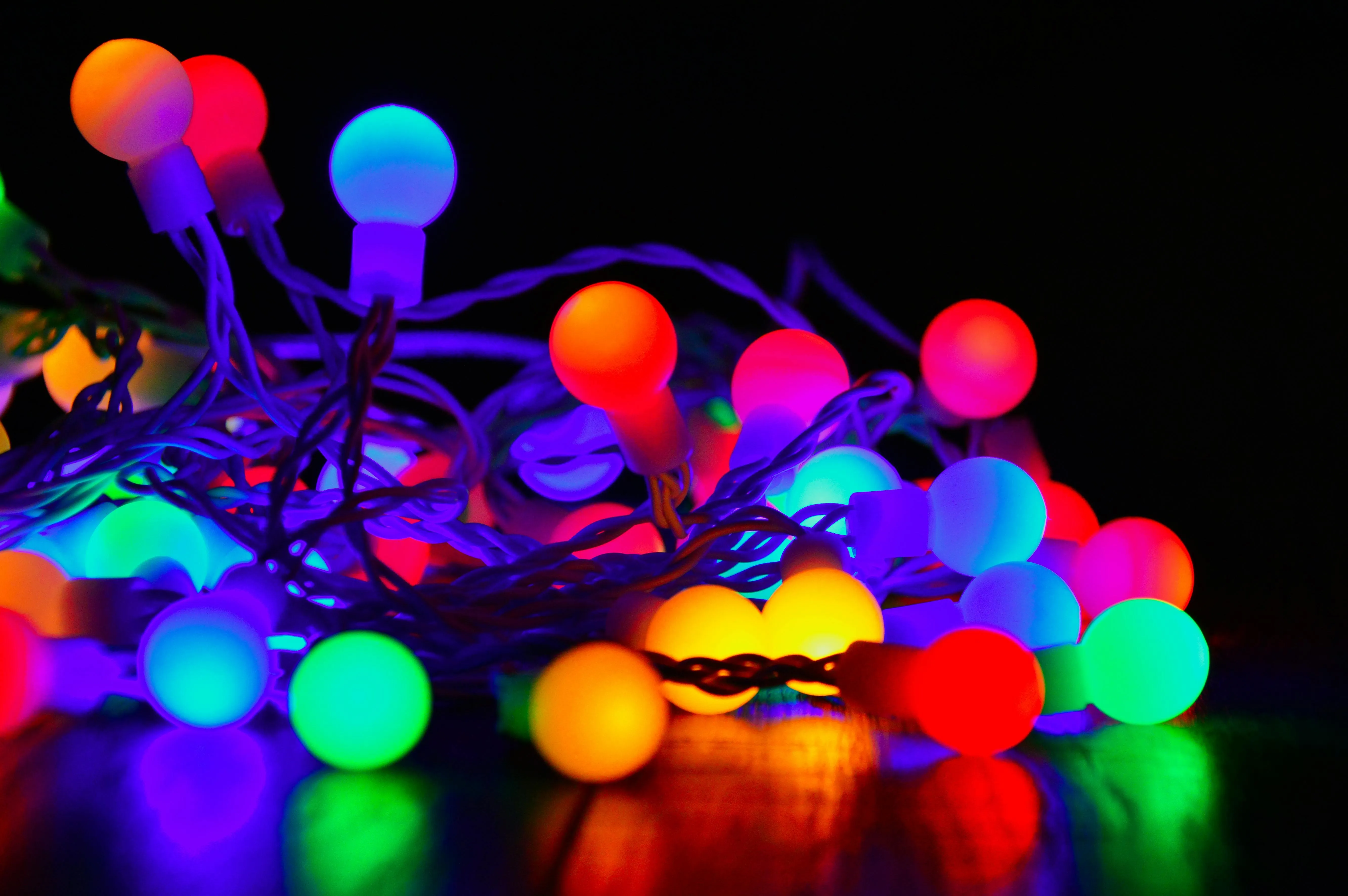 Multicoloured glowing fairy lights on a black surface image