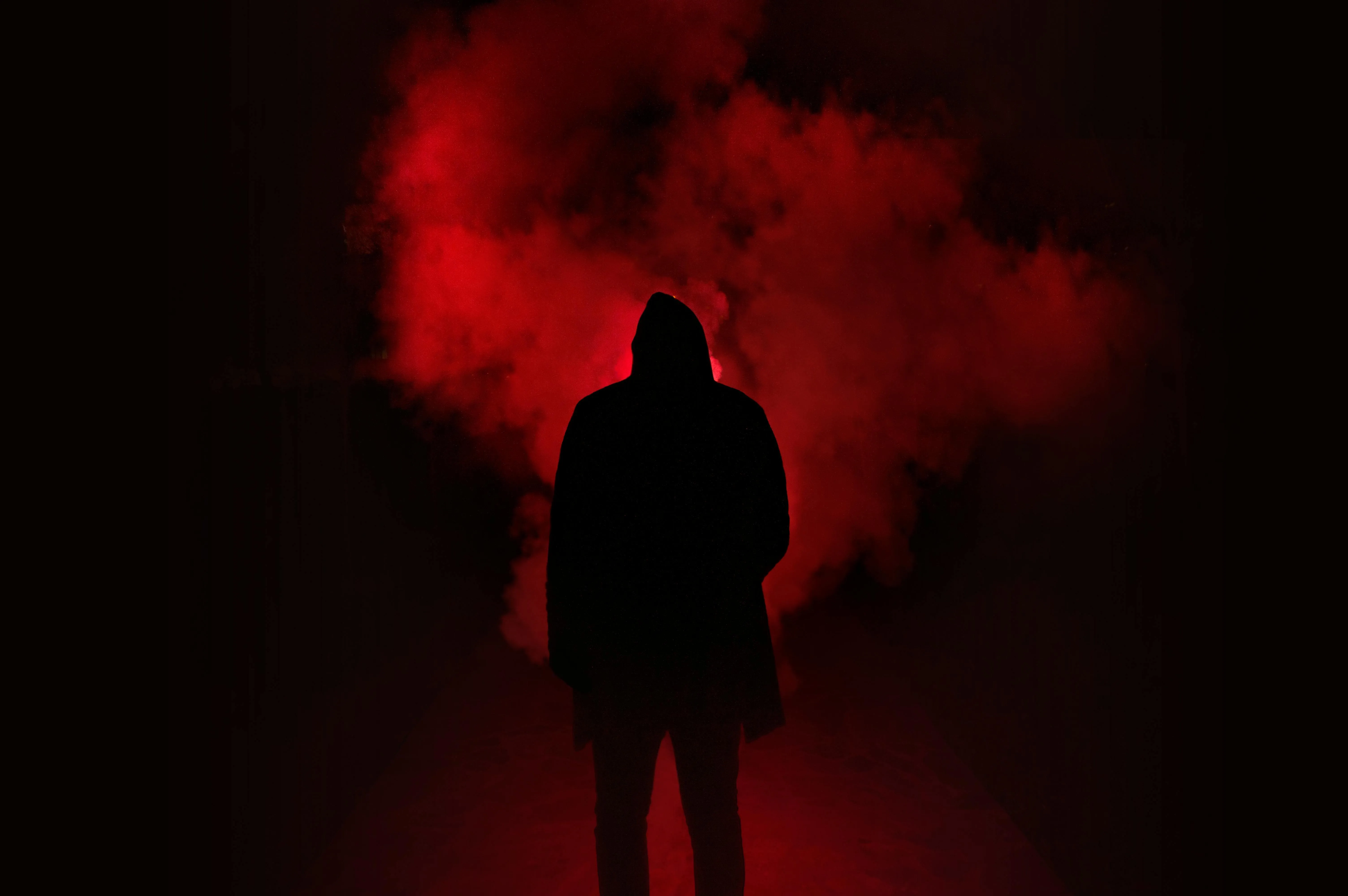 Mysterious man in red smoke with a dark dramatic atmosphere