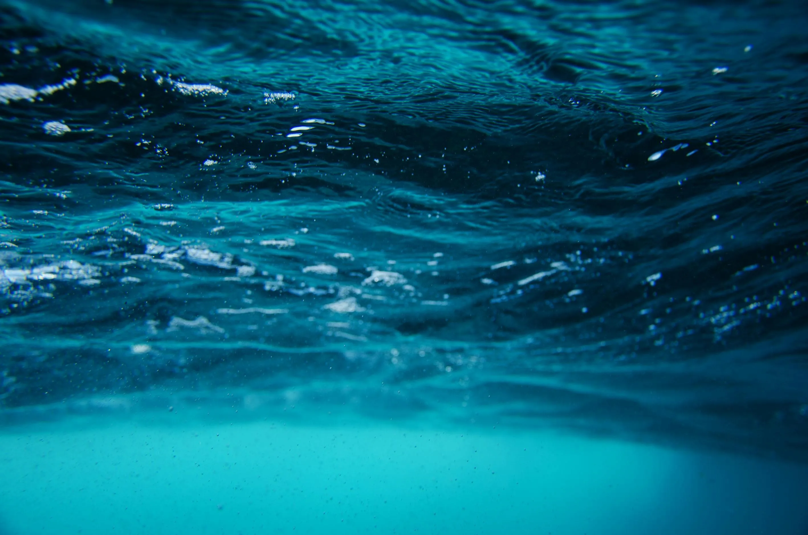 Ocean water surface showing underwater waves and bubbles