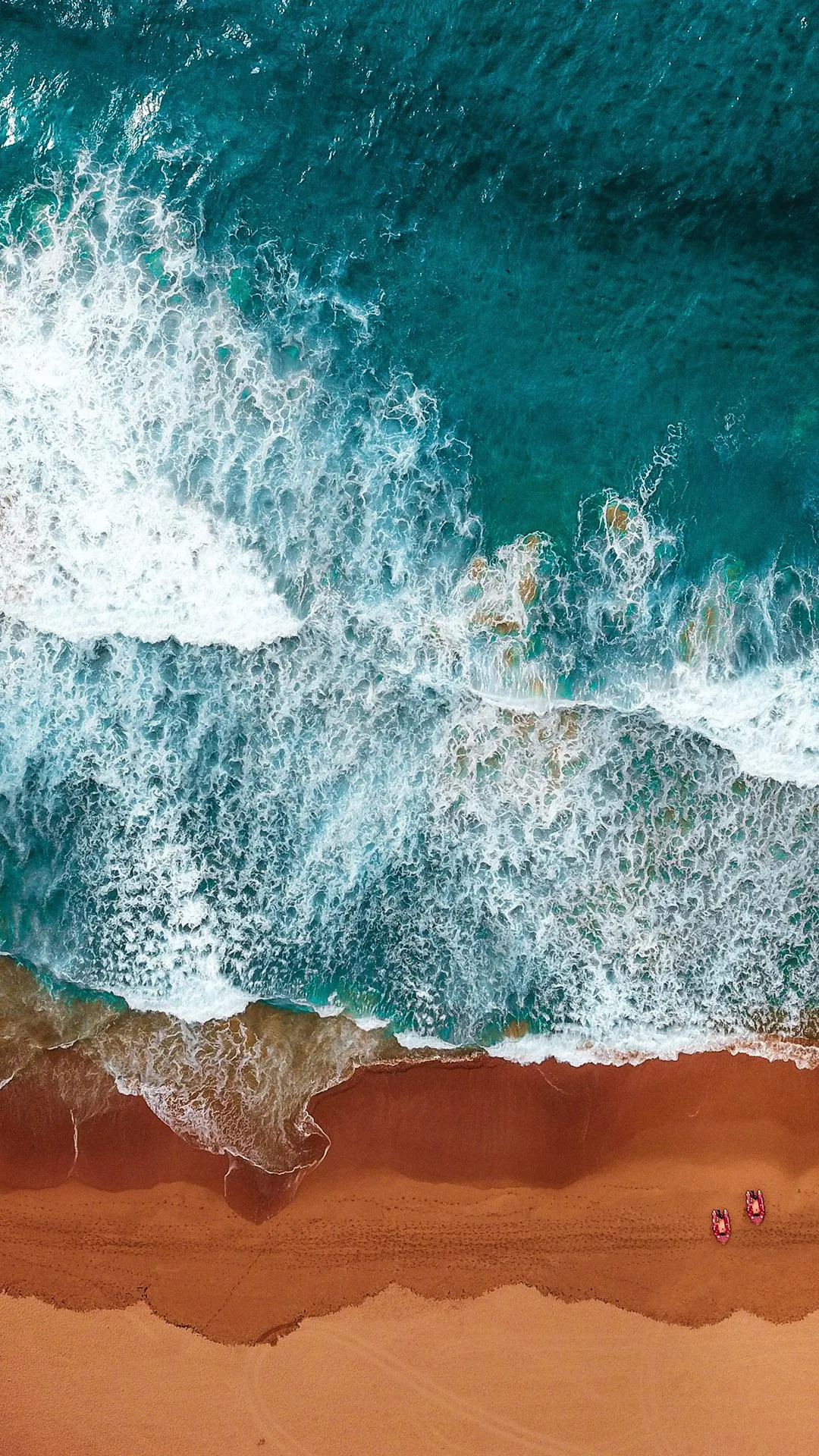 Ocean Waves Crashing on Sandy Beach with Clear Blue Water