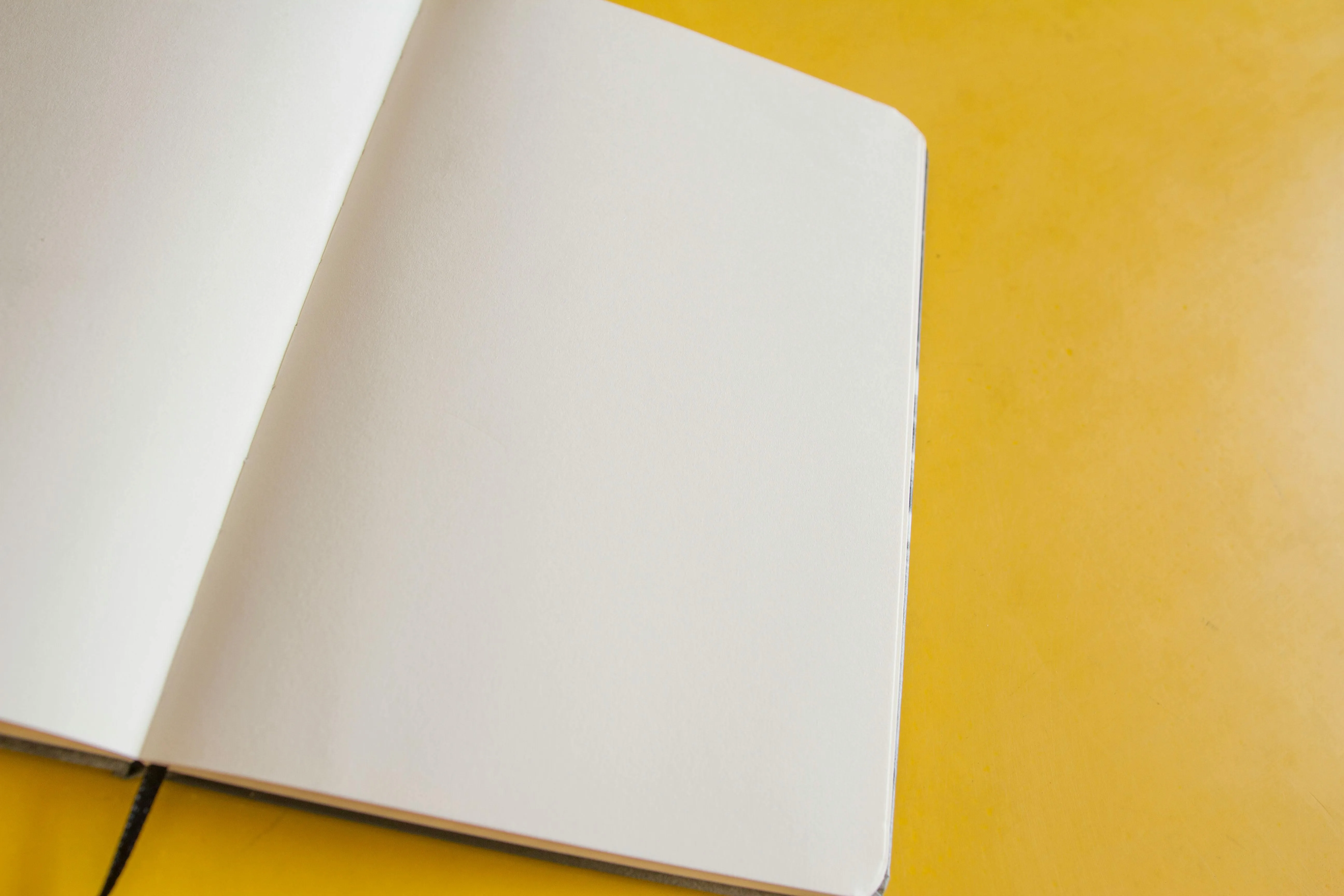 Open blank notebook on a yellow background free Wallpaper