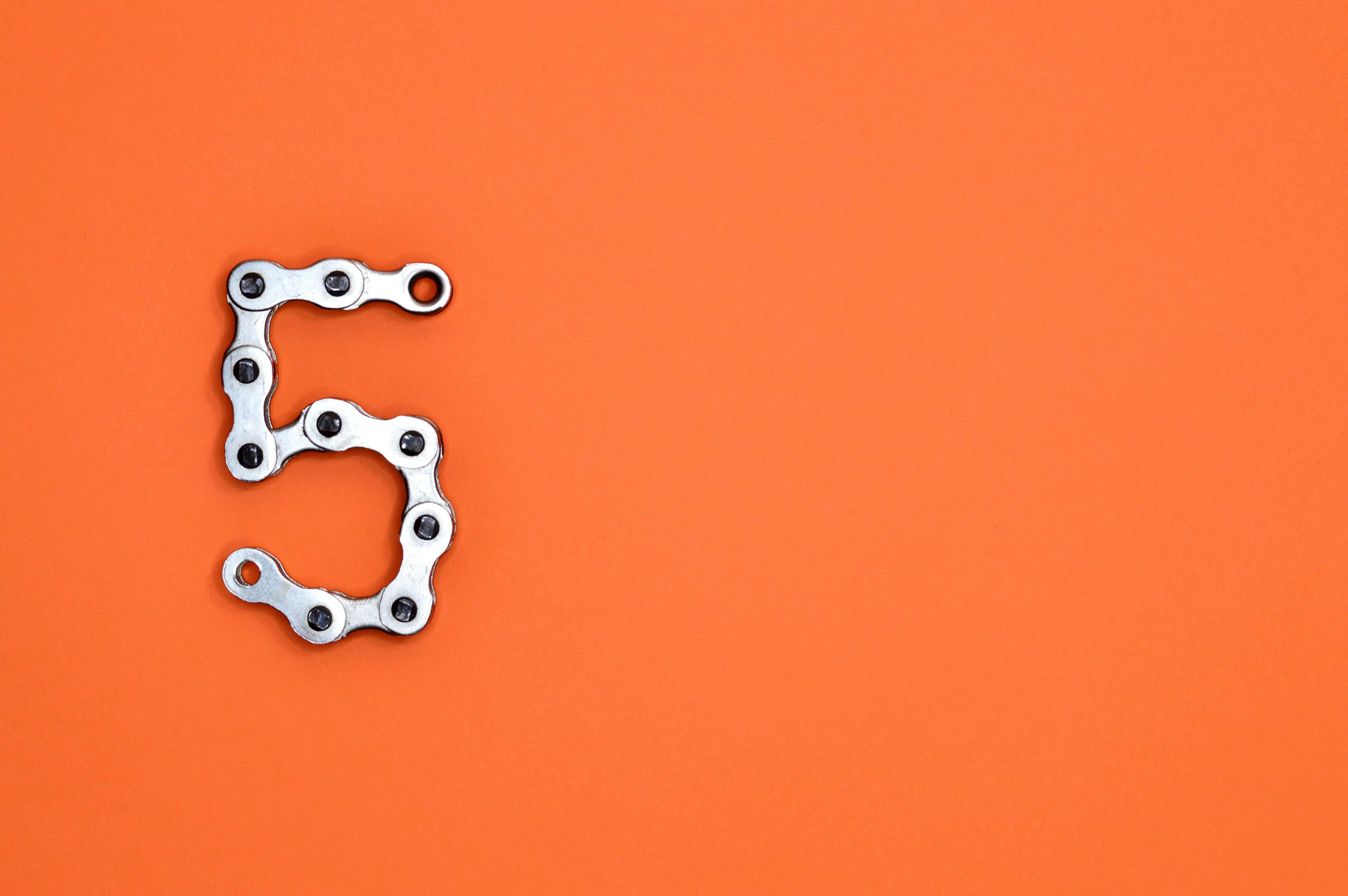 Orange background with number five made of a metal chain