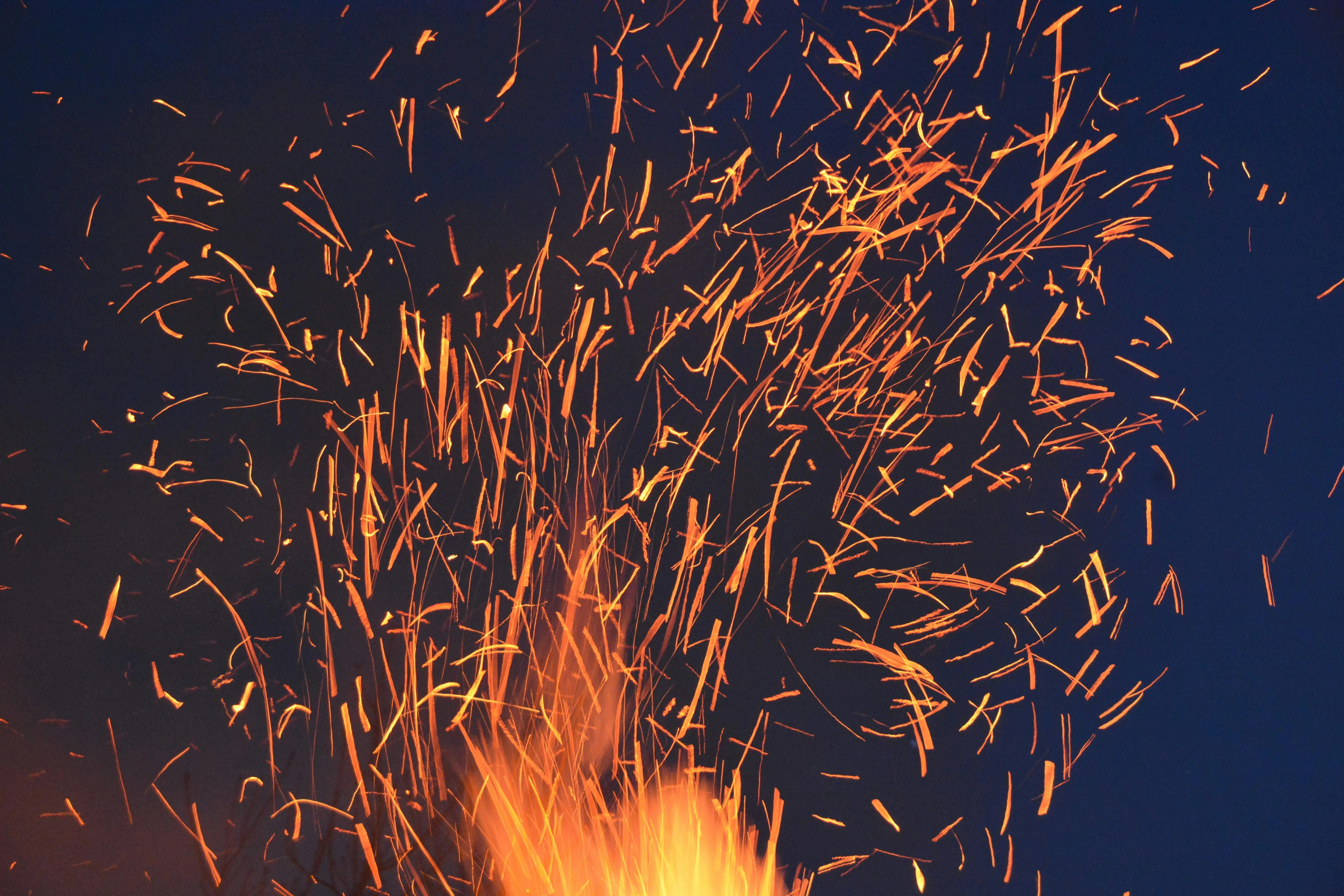 Orange fire sparks flying against a dark blue background