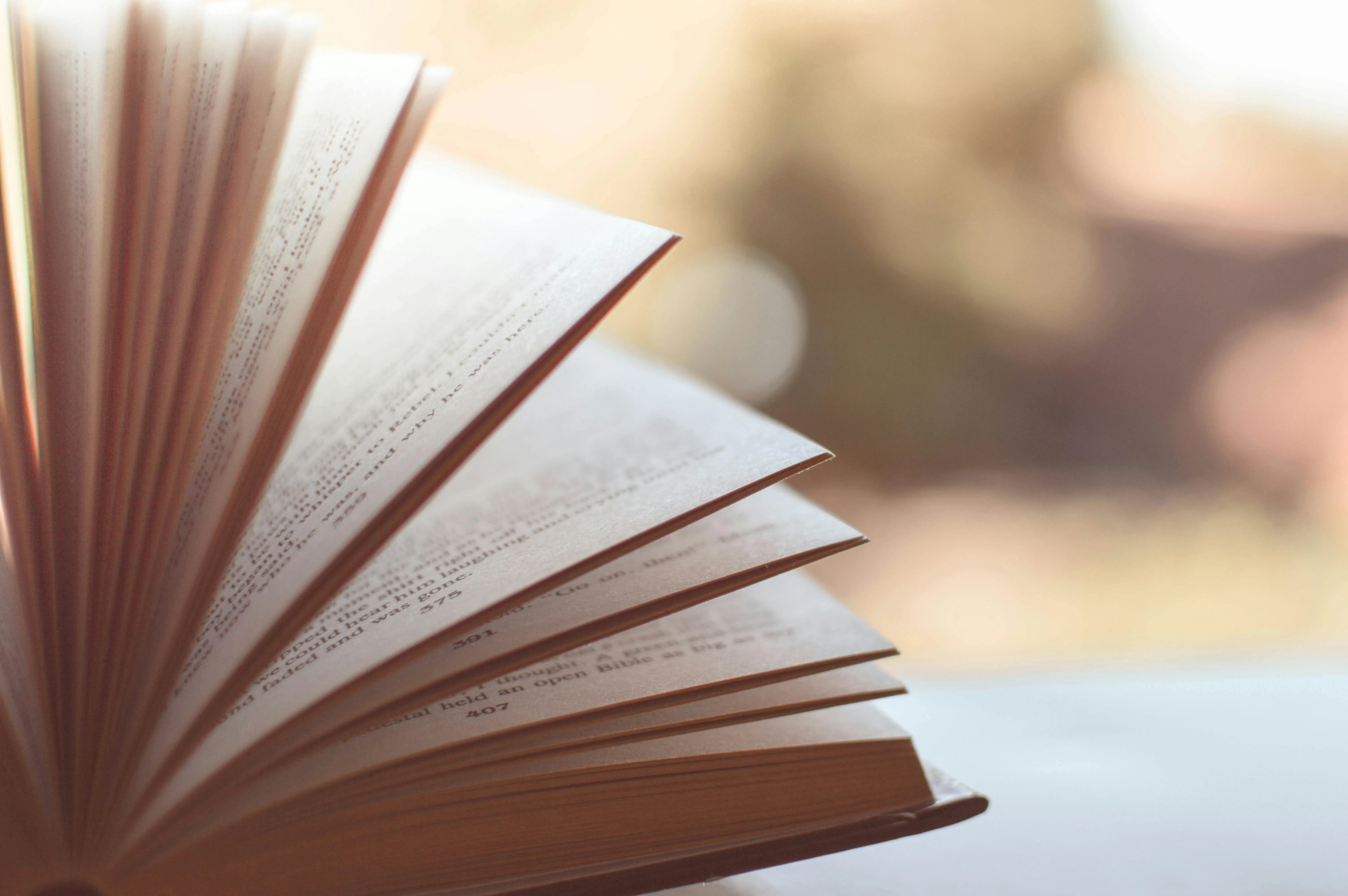 Pages of open book flipping in soft warm light Wallpaper