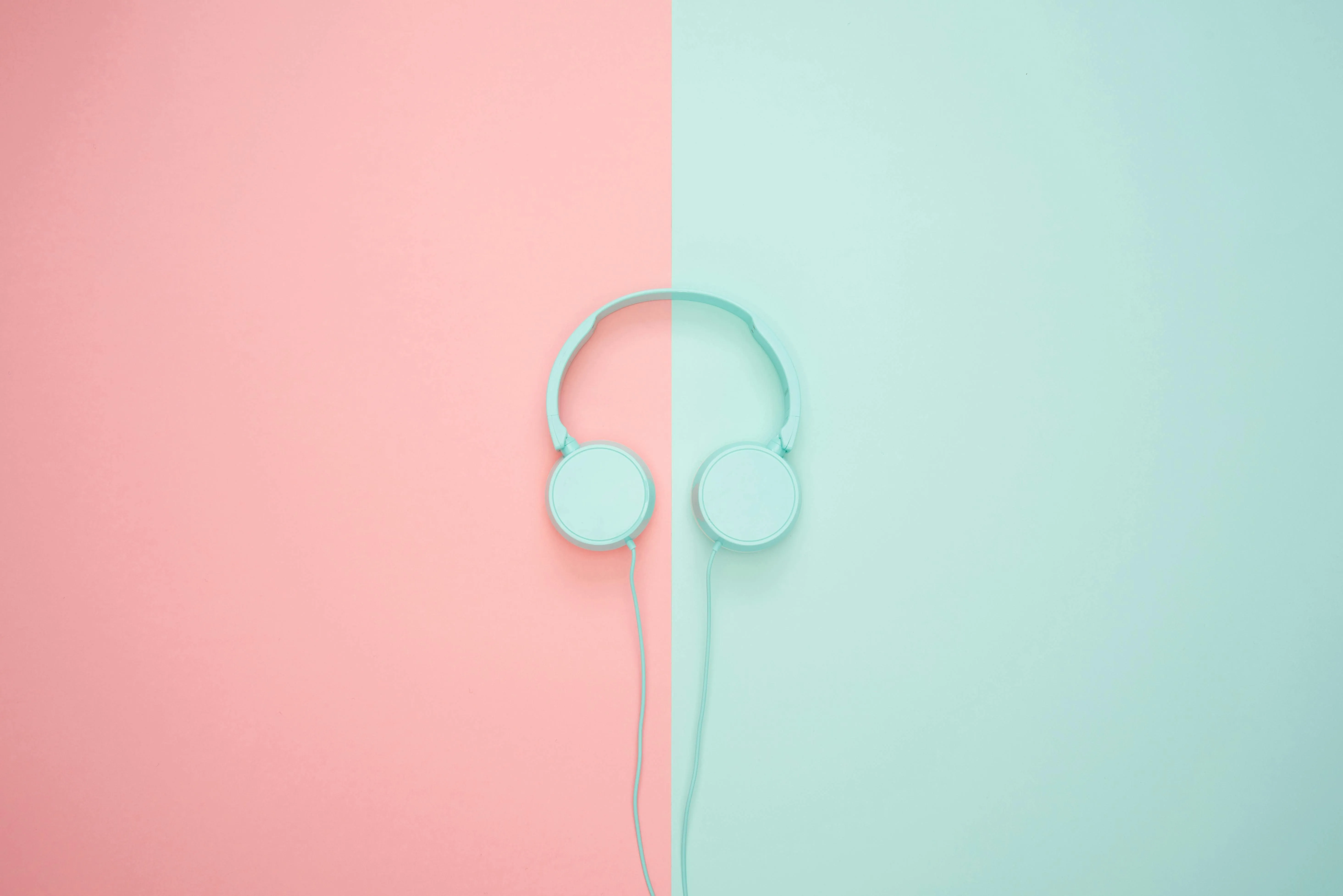 Pastel pink and blue split background with headphones image
