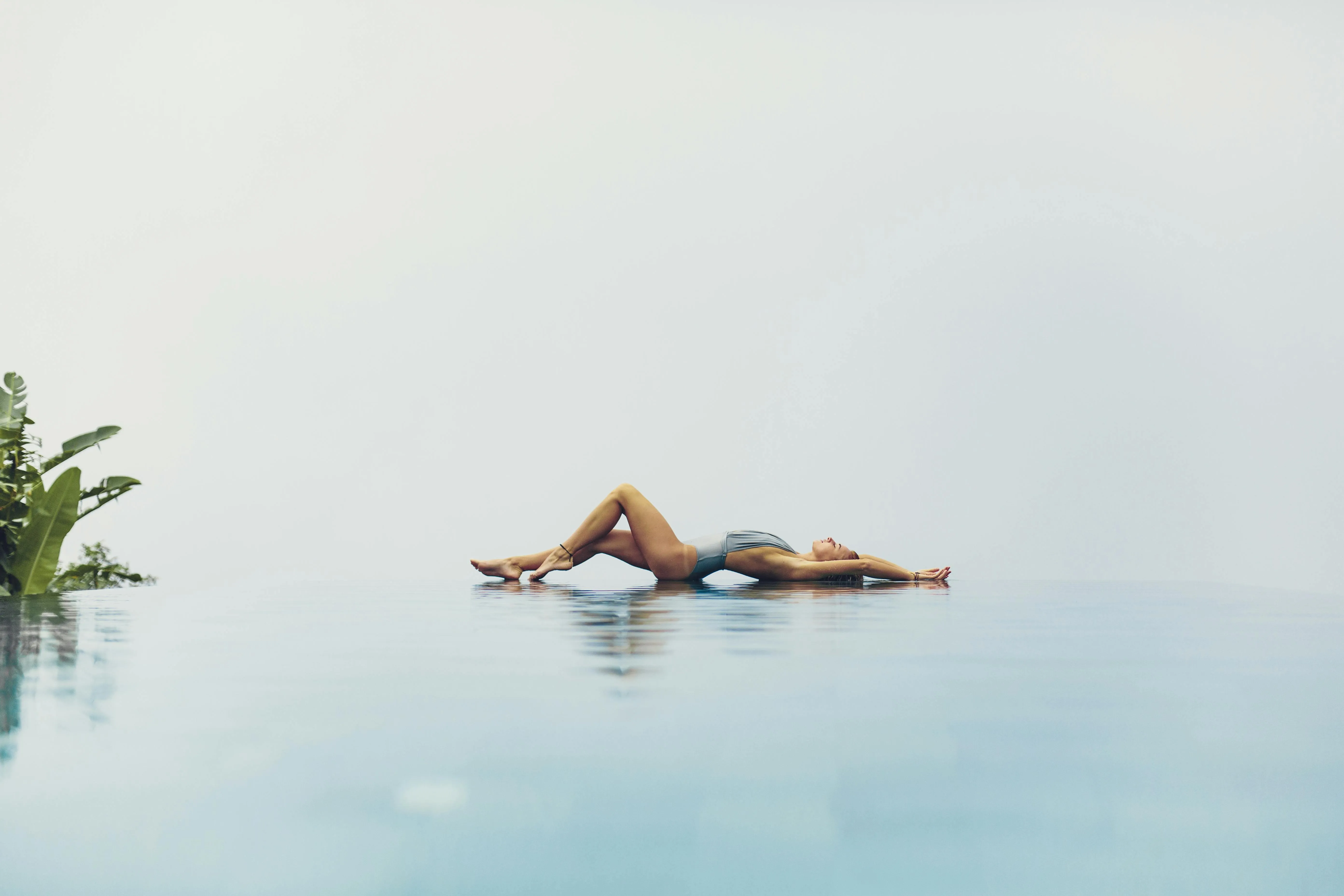 Person floating peacefully in calm blue water Wallpaper